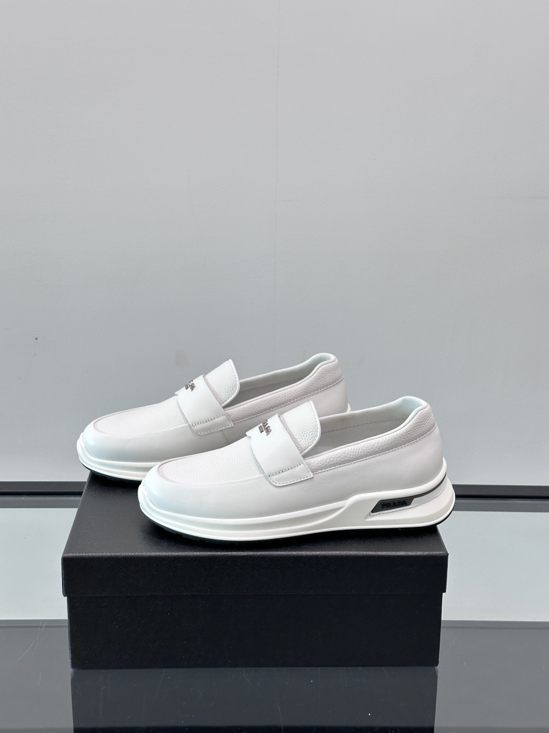 Prada/普拉达 男士新款一脚蹬懒人休闲鞋👟这款运动鞋采用光滑小牛皮革和摔纹牛皮拼接鞋面，一脚蹬乐福鞋