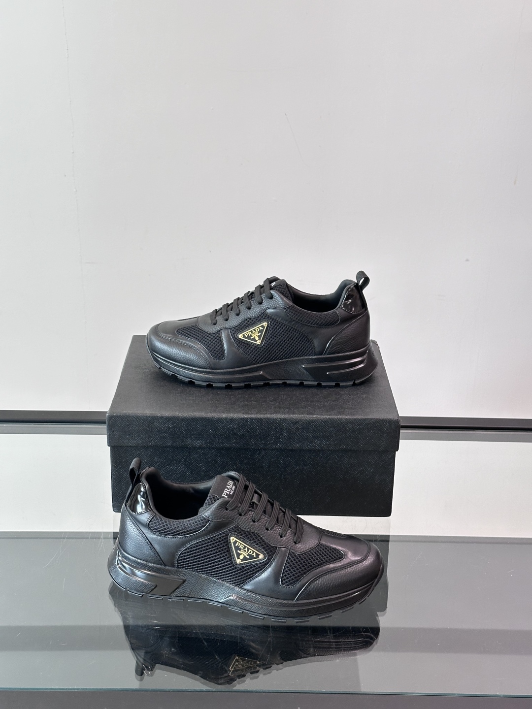 Prada/普拉达 男士新款运动休闲鞋，这款运动鞋鞋面采用进口小牛皮拼接透气网面，外侧饰以P家经典金属三