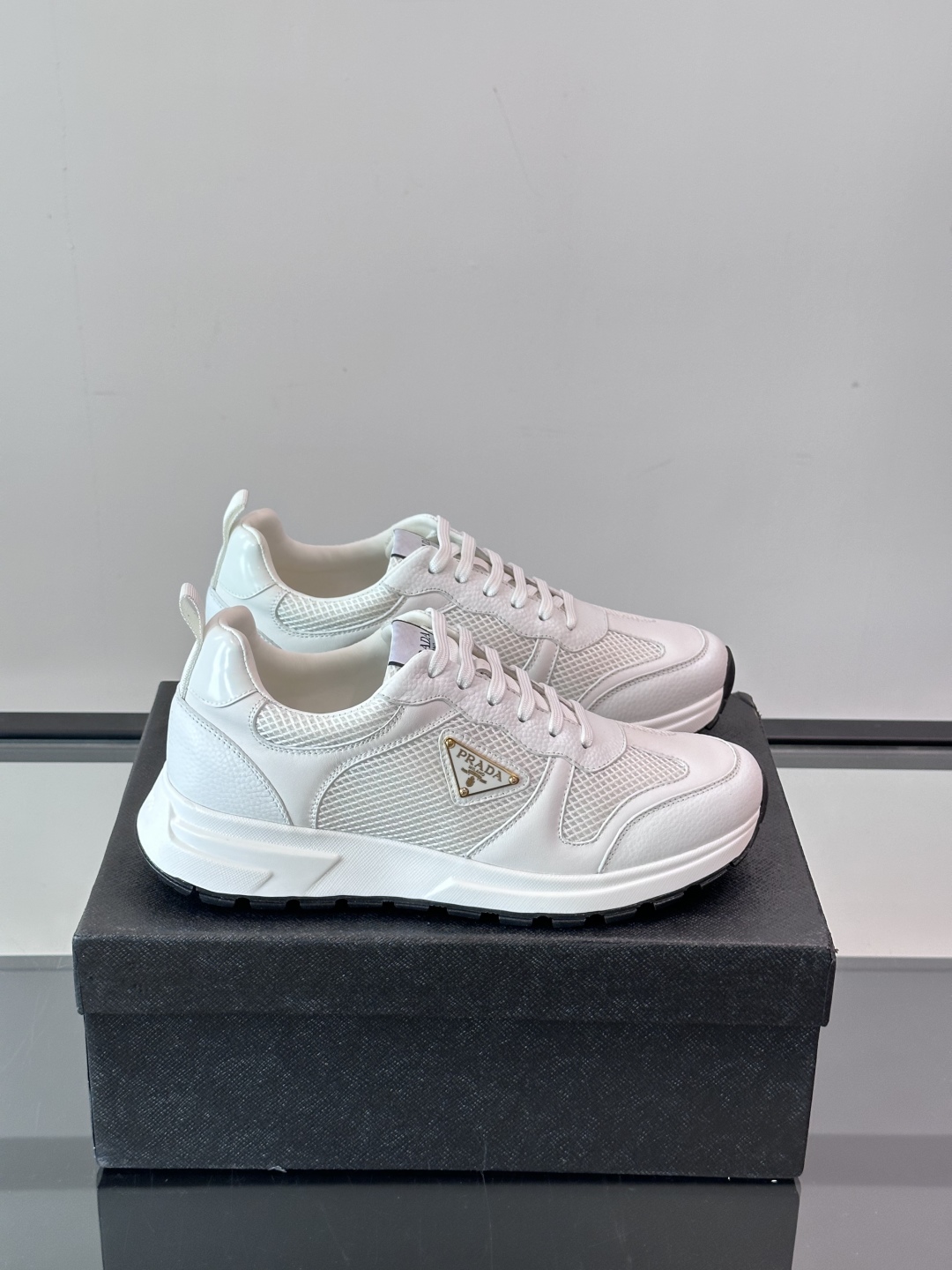 Prada/普拉达 男士新款运动休闲鞋，这款运动鞋鞋面采用进口小牛皮拼接透气网面，外侧饰以P家经典金属三
