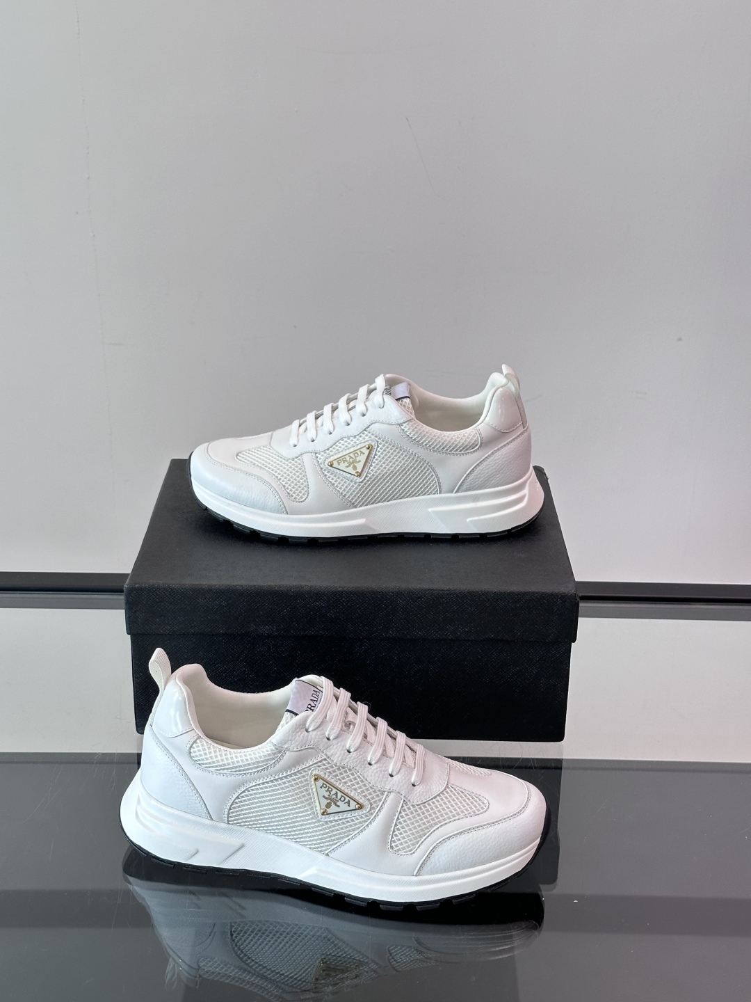 Prada/普拉达 男士新款运动休闲鞋，这款运动鞋鞋面采用进口小牛皮拼接透气网面，外侧饰以P家经典金属三
