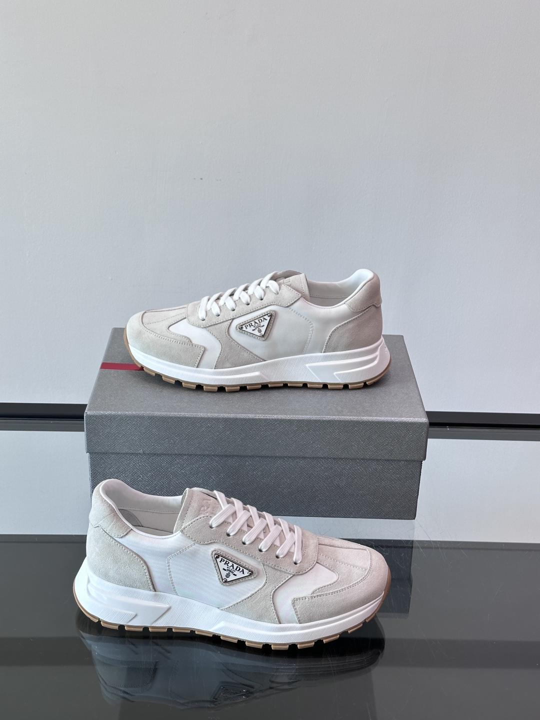 Prada/普拉达 男士新款运动休闲鞋，这款运动鞋鞋面采用进口小牛皮。外侧饰以P家经典金属三角珐琅徽标，