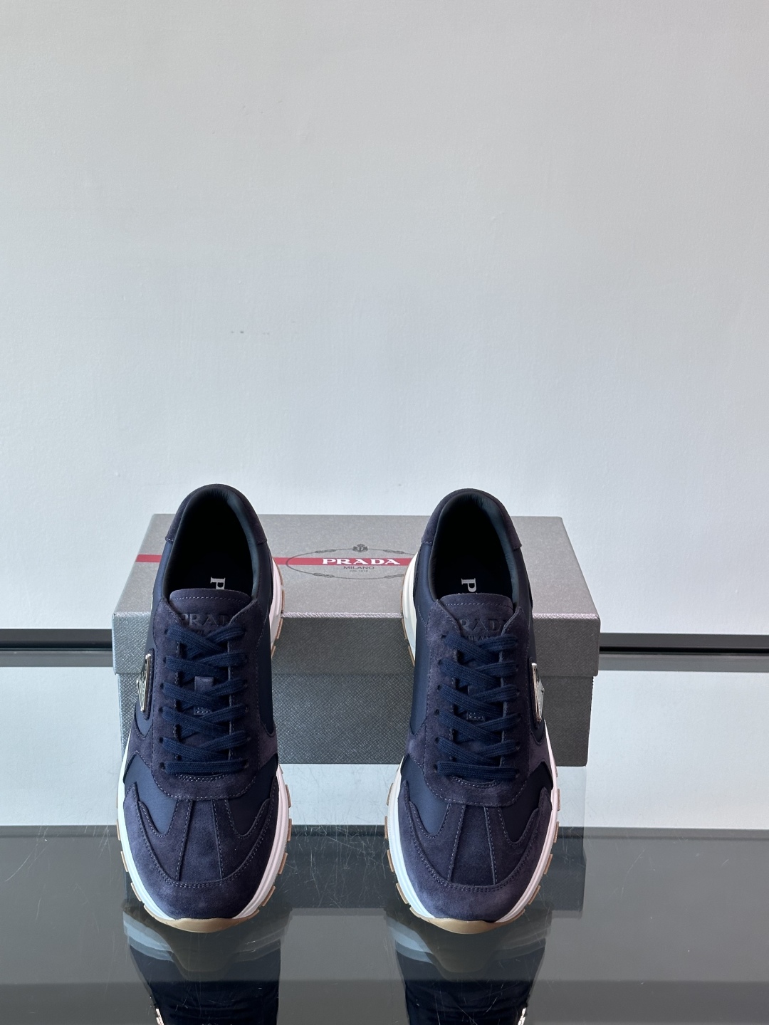 Prada/普拉达 男士新款运动休闲鞋，这款运动鞋鞋面采用进口小牛皮。外侧饰以P家经典金属三角珐琅徽标，