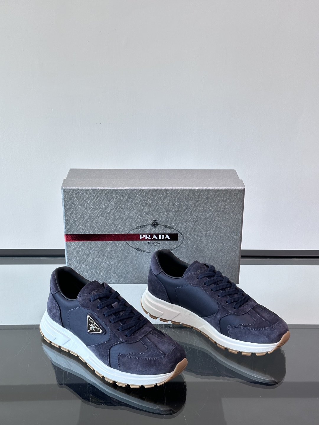 Prada/普拉达 男士新款运动休闲鞋，这款运动鞋鞋面采用进口小牛皮。外侧饰以P家经典金属三角珐琅徽标，