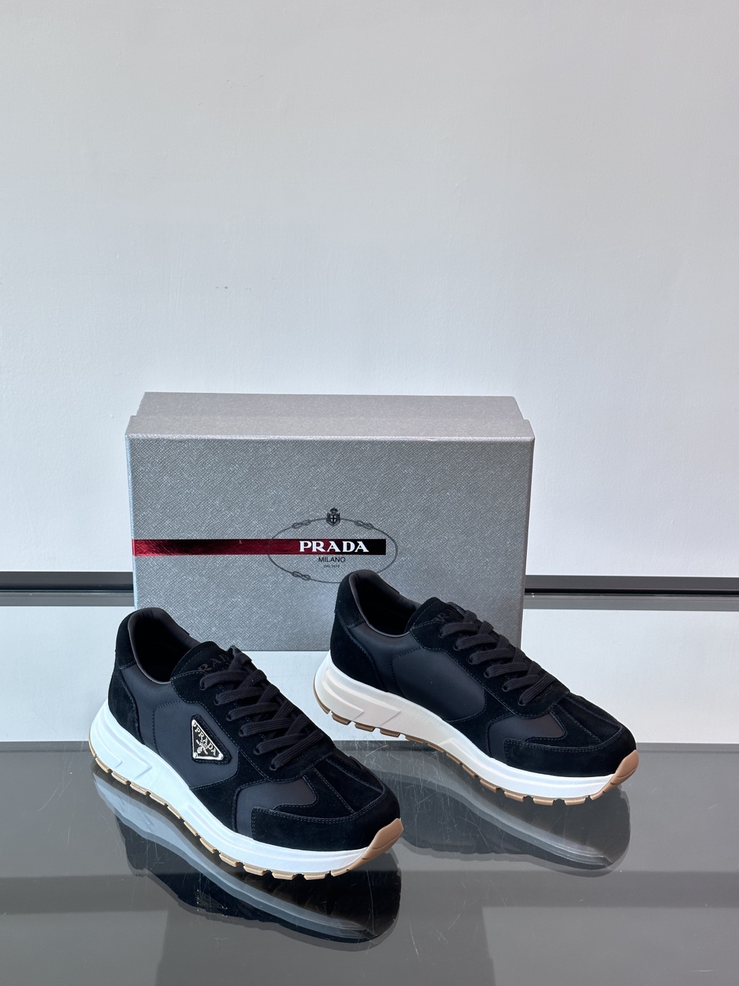 Prada/普拉达 男士新款运动休闲鞋，这款运动鞋鞋面采用进口小牛皮。外侧饰以P家经典金属三角珐琅徽标，