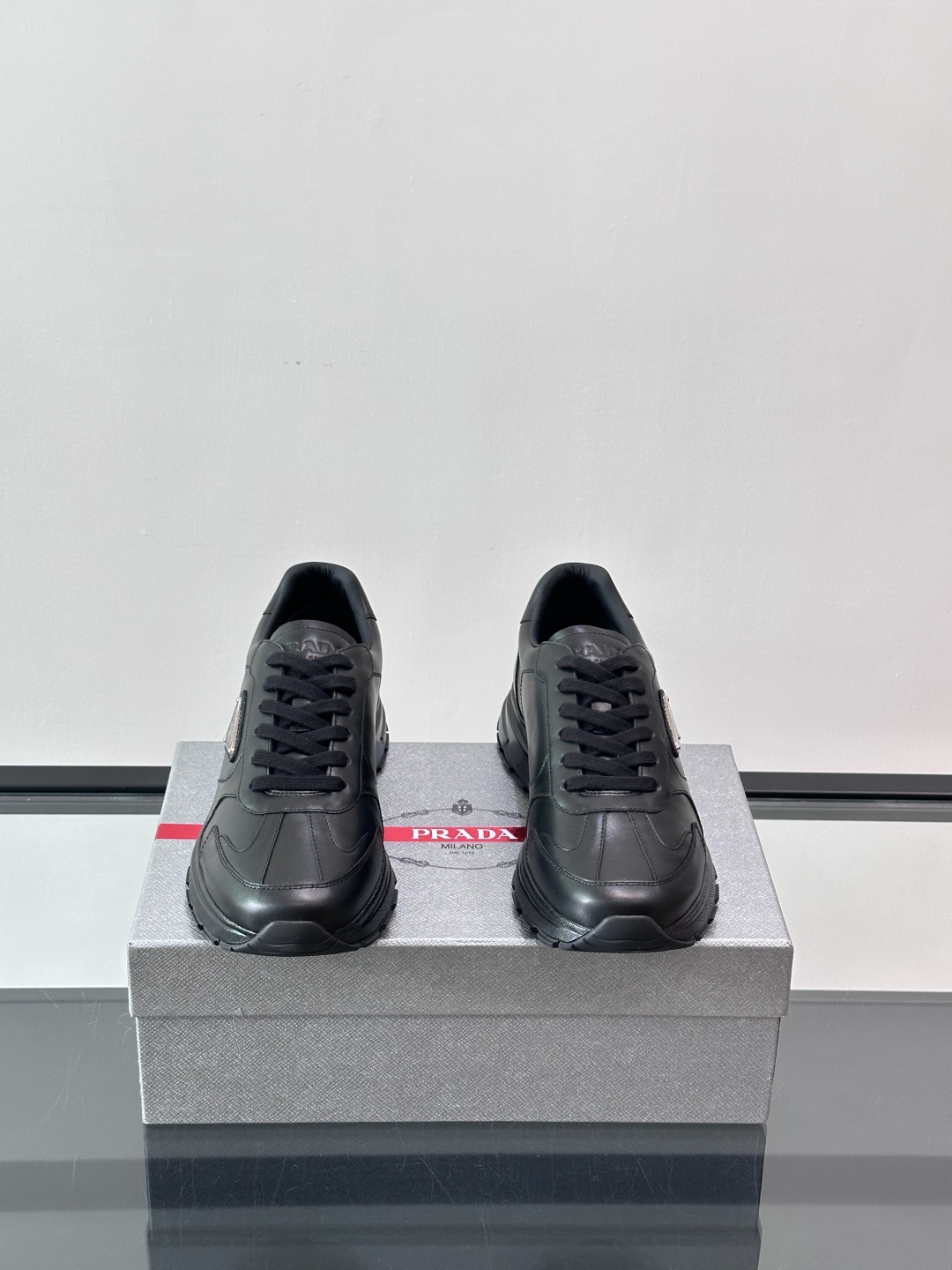 Prada/普拉达 男士新款运动休闲鞋，这款运动鞋鞋面采用进口小牛皮。外侧饰以P家经典金属三角珐琅徽标，