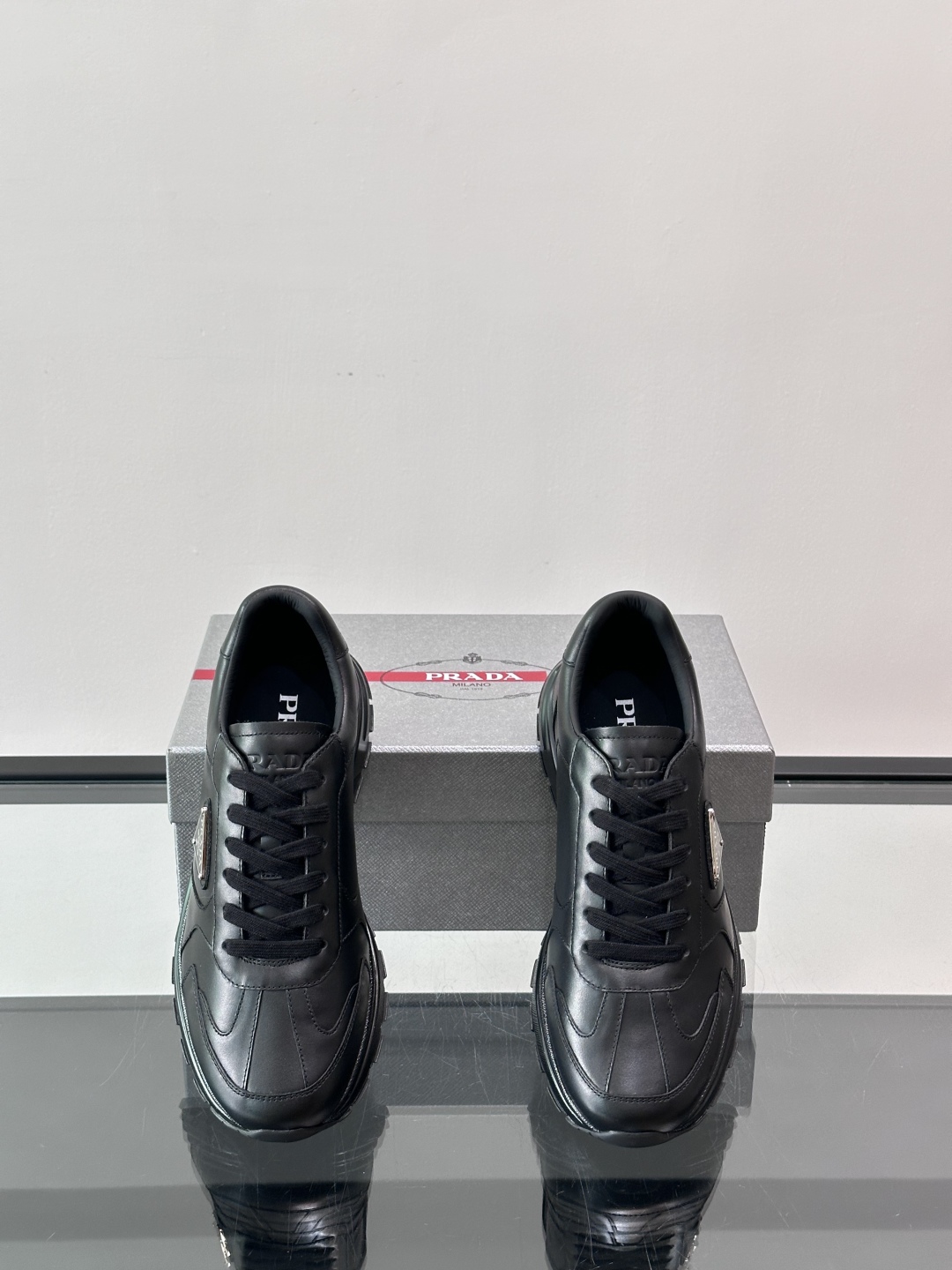 Prada/普拉达 男士新款运动休闲鞋，这款运动鞋鞋面采用进口小牛皮。外侧饰以P家经典金属三角珐琅徽标，