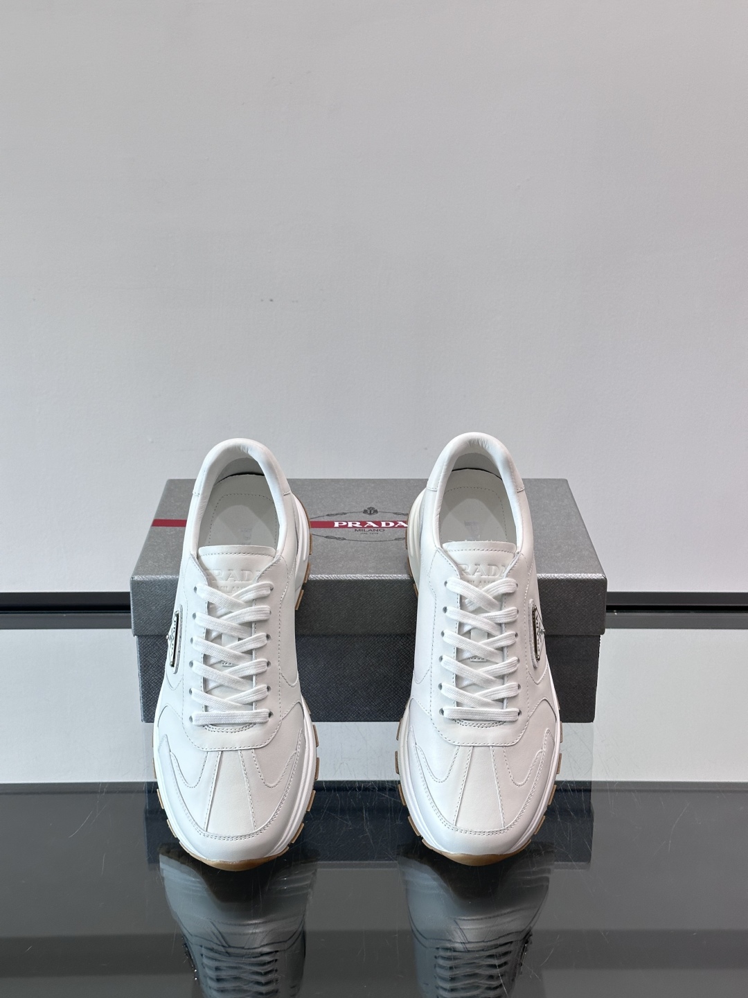 Prada/普拉达 男士新款运动休闲鞋，这款运动鞋鞋面采用进口小牛皮。外侧饰以P家经典金属三角珐琅徽标，