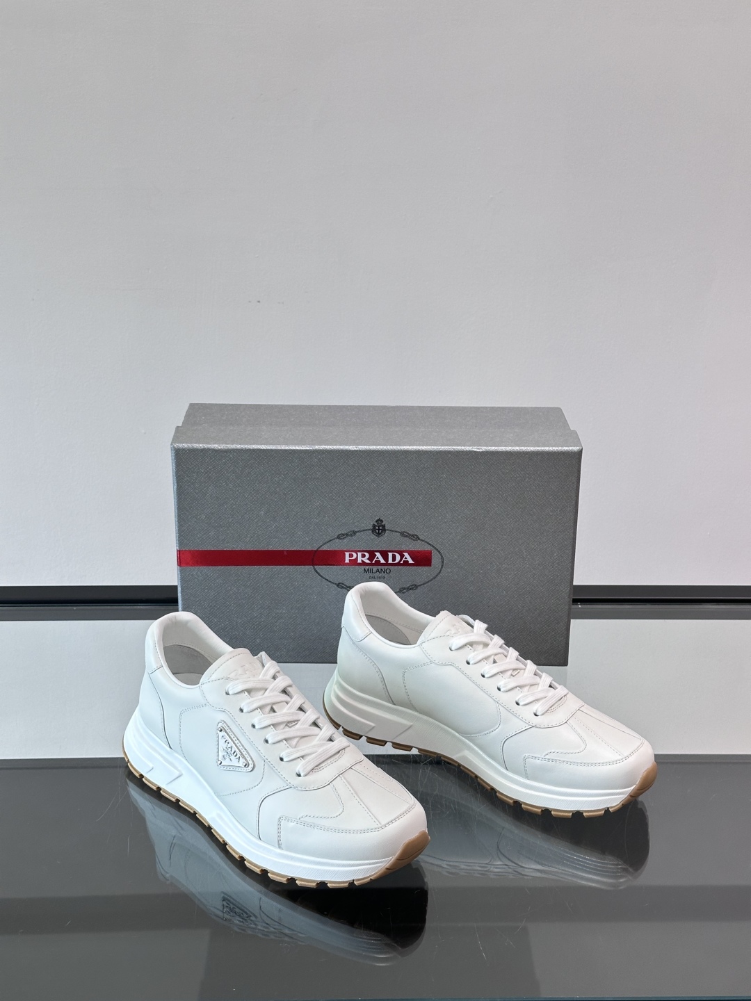 Prada/普拉达 男士新款运动休闲鞋，这款运动鞋鞋面采用进口小牛皮。外侧饰以P家经典金属三角珐琅徽标，