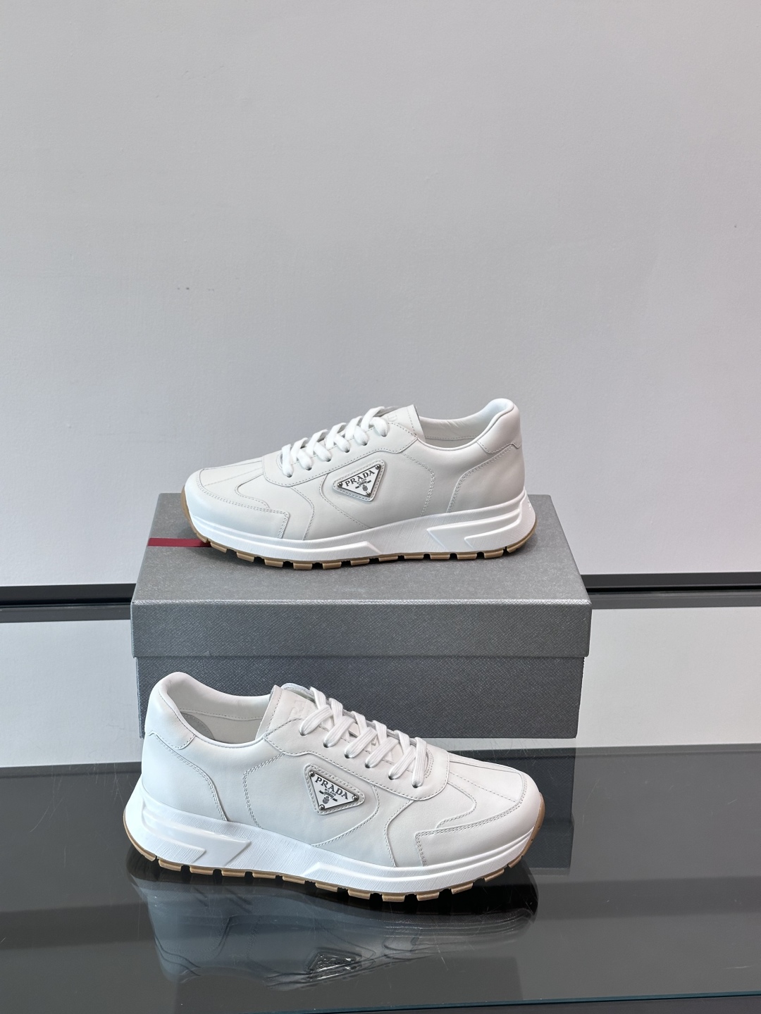 Prada/普拉达 男士新款运动休闲鞋，这款运动鞋鞋面采用进口小牛皮。外侧饰以P家经典金属三角珐琅徽标，