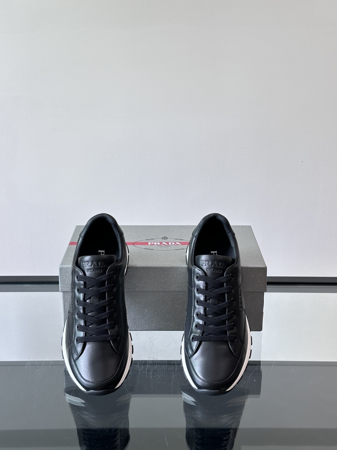Prada/普拉达 男士新款运动休闲鞋，这款运动鞋鞋面采用进口小牛皮。外侧饰以P家经典金属三角珐琅徽标，