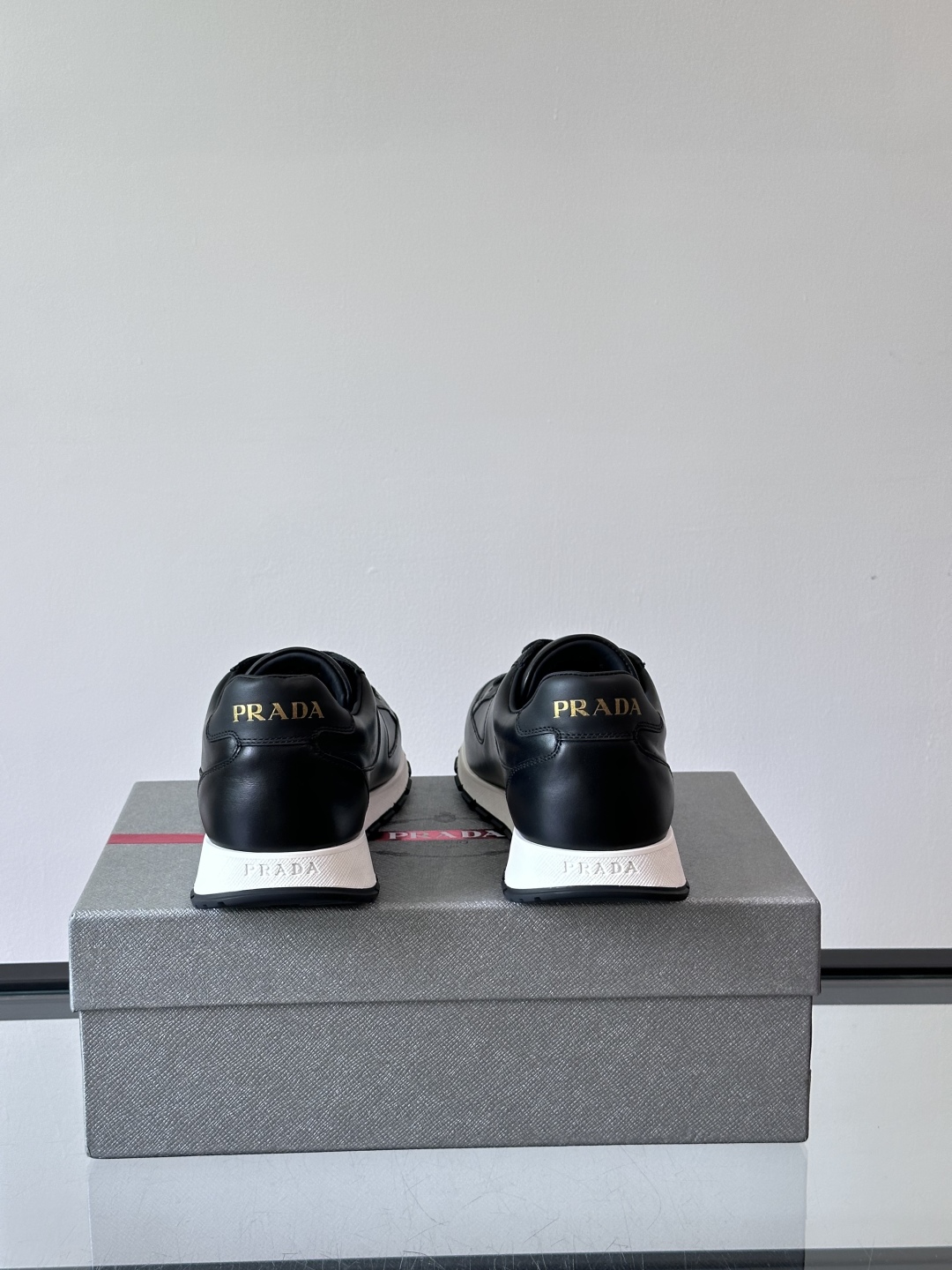Prada/普拉达 男士新款运动休闲鞋，这款运动鞋鞋面采用进口小牛皮。外侧饰以P家经典金属三角珐琅徽标，