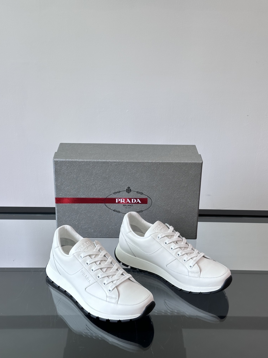Prada/普拉达 男士新款运动休闲鞋，这款运动鞋鞋面采用进口小牛皮。外侧饰以P家经典金属三角珐琅徽标，