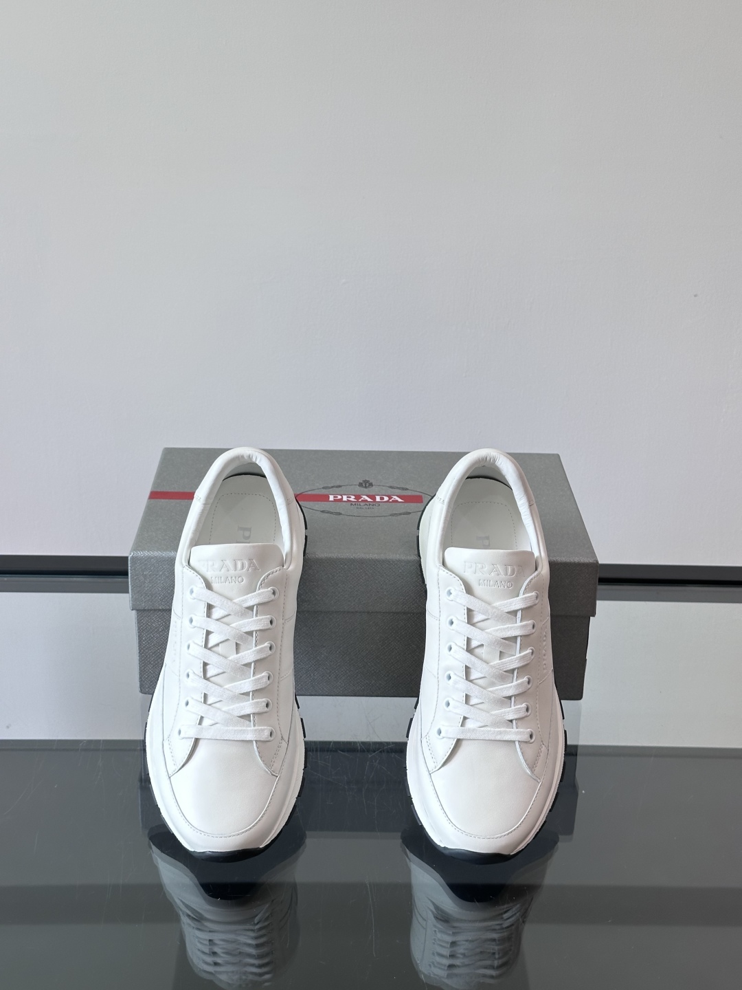 Prada/普拉达 男士新款运动休闲鞋，这款运动鞋鞋面采用进口小牛皮。外侧饰以P家经典金属三角珐琅徽标，