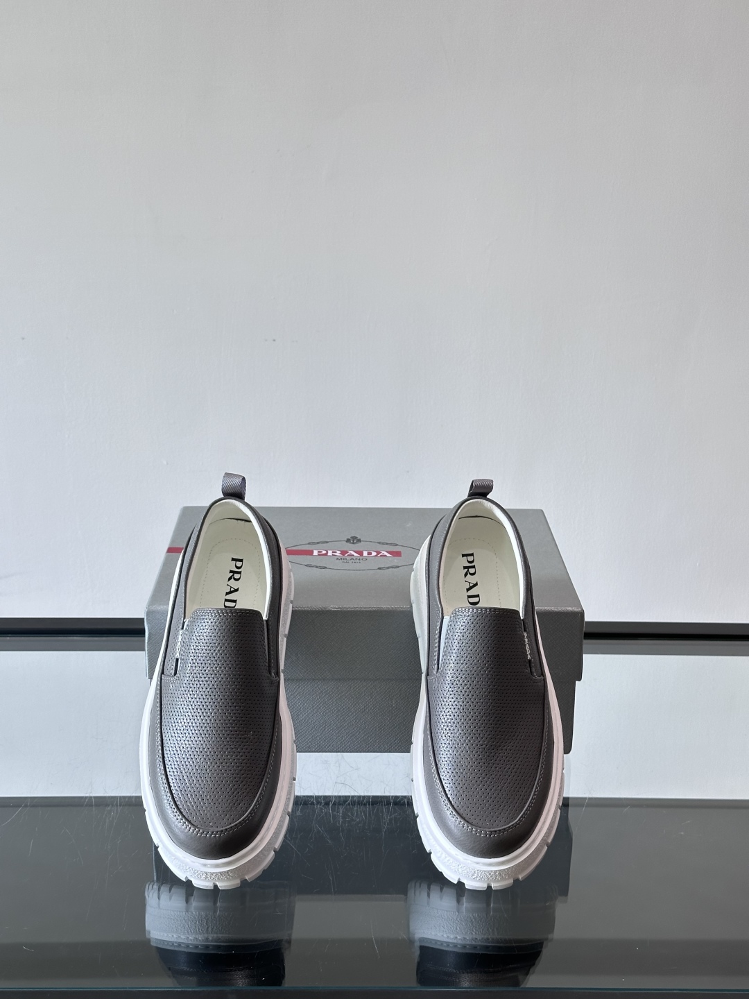 Prada/普拉达 男士新款一脚蹬懒人休闲鞋👟这款运动鞋采用光滑小牛皮革和摔纹牛皮拼接鞋面，一脚蹬乐福鞋