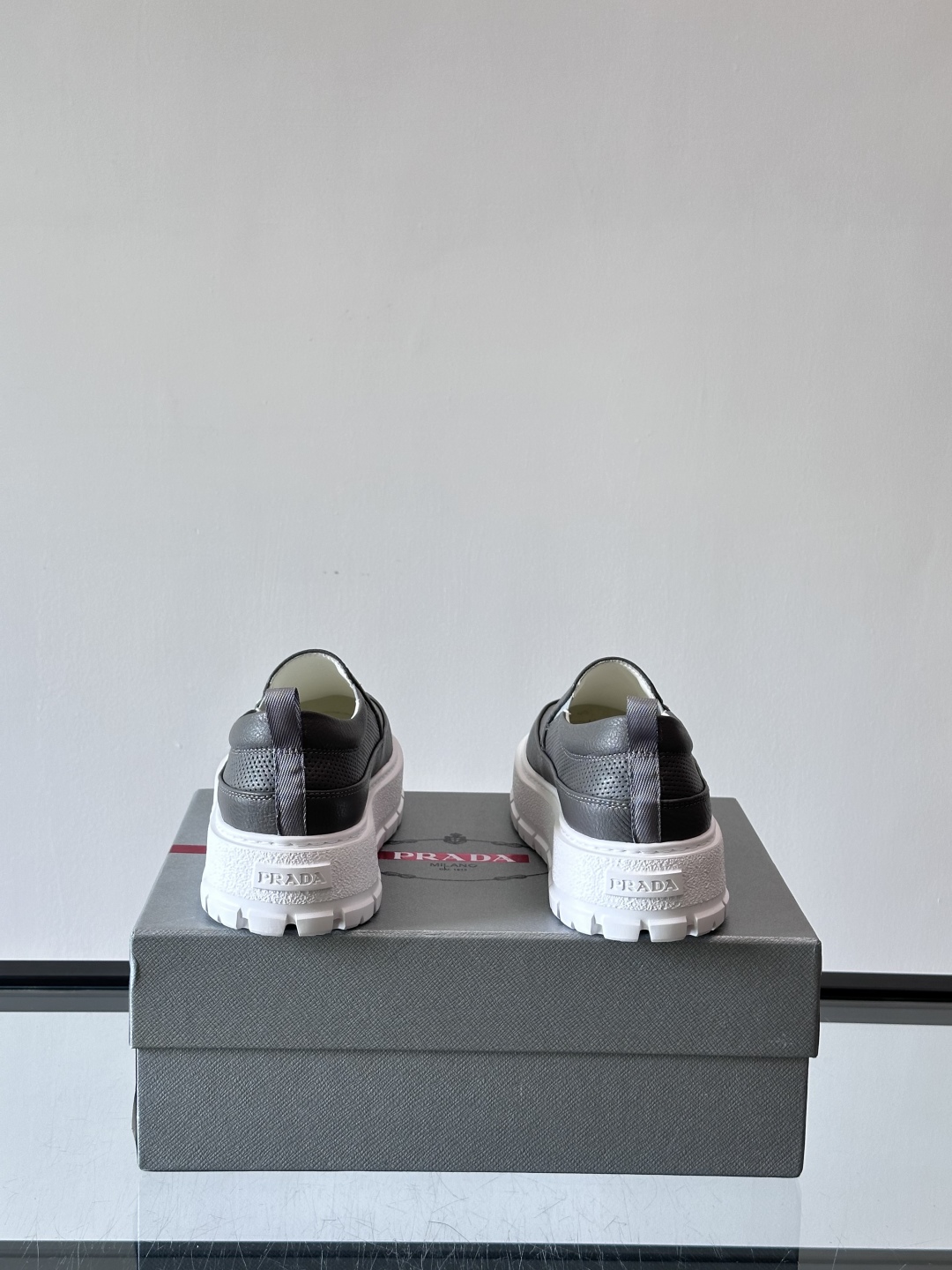 Prada/普拉达 男士新款一脚蹬懒人休闲鞋👟这款运动鞋采用光滑小牛皮革和摔纹牛皮拼接鞋面，一脚蹬乐福鞋