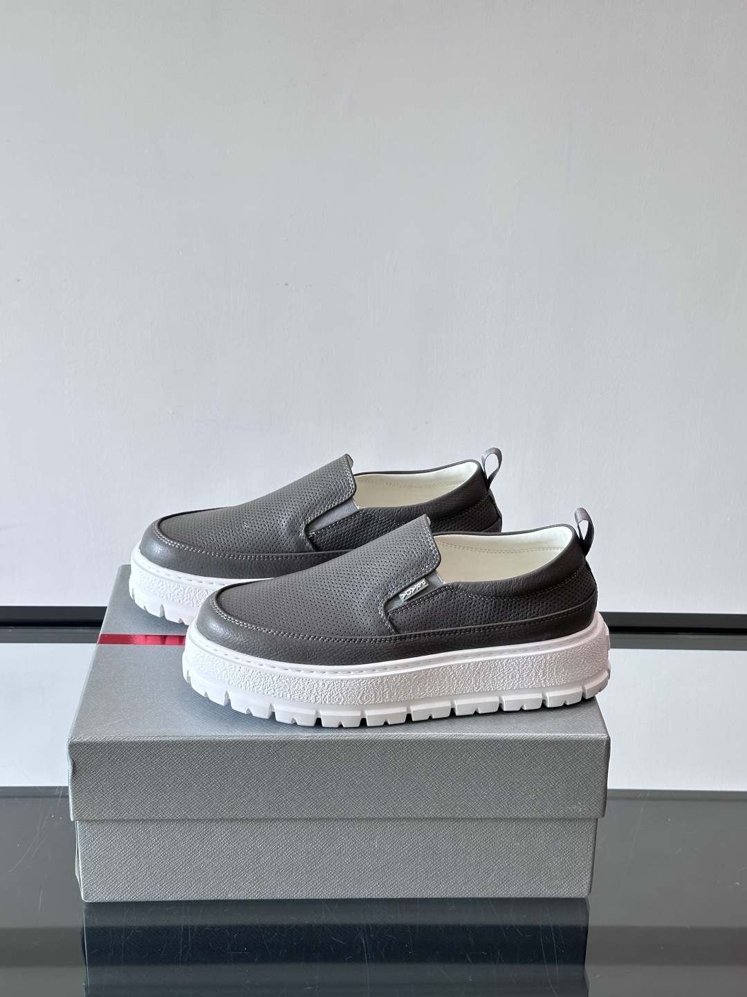 Prada/普拉达 男士新款一脚蹬懒人休闲鞋👟这款运动鞋采用光滑小牛皮革和摔纹牛皮拼接鞋面，一脚蹬乐福鞋