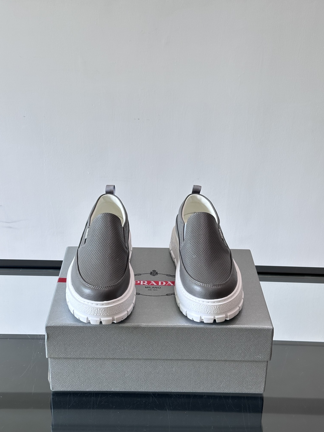 Prada/普拉达 男士新款一脚蹬懒人休闲鞋👟这款运动鞋采用光滑小牛皮革和摔纹牛皮拼接鞋面，一脚蹬乐福鞋