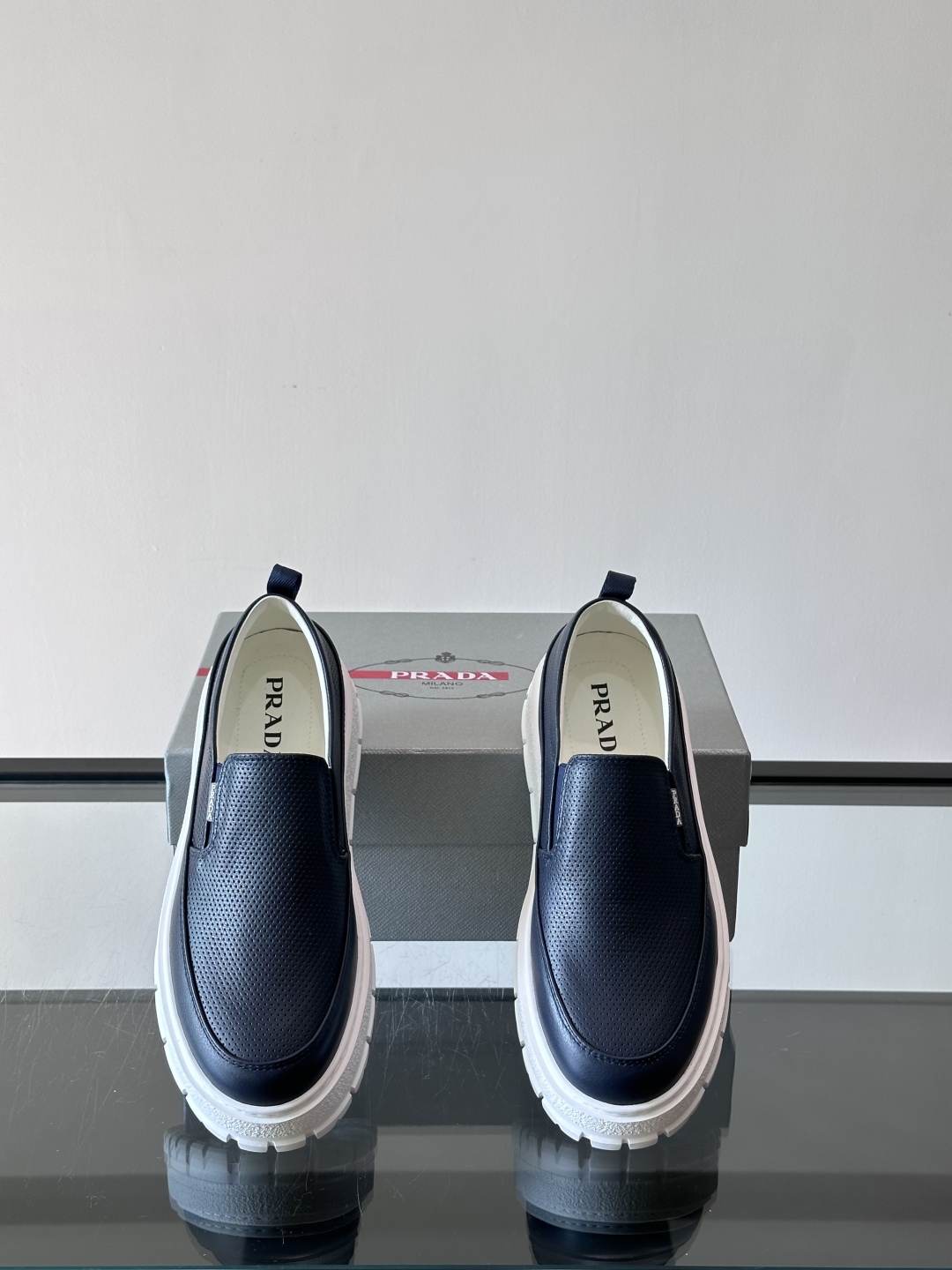 Prada/普拉达 男士新款一脚蹬懒人休闲鞋👟这款运动鞋采用光滑小牛皮革和摔纹牛皮拼接鞋面，一脚蹬乐福鞋