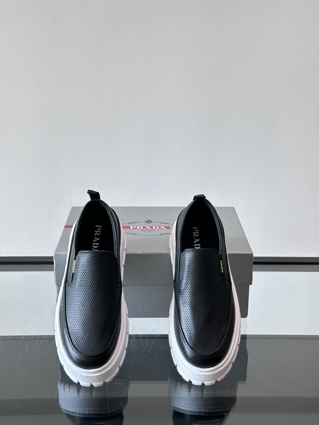Prada/普拉达 男士新款一脚蹬懒人休闲鞋👟这款运动鞋采用光滑小牛皮革和摔纹牛皮拼接鞋面，一脚蹬乐福鞋