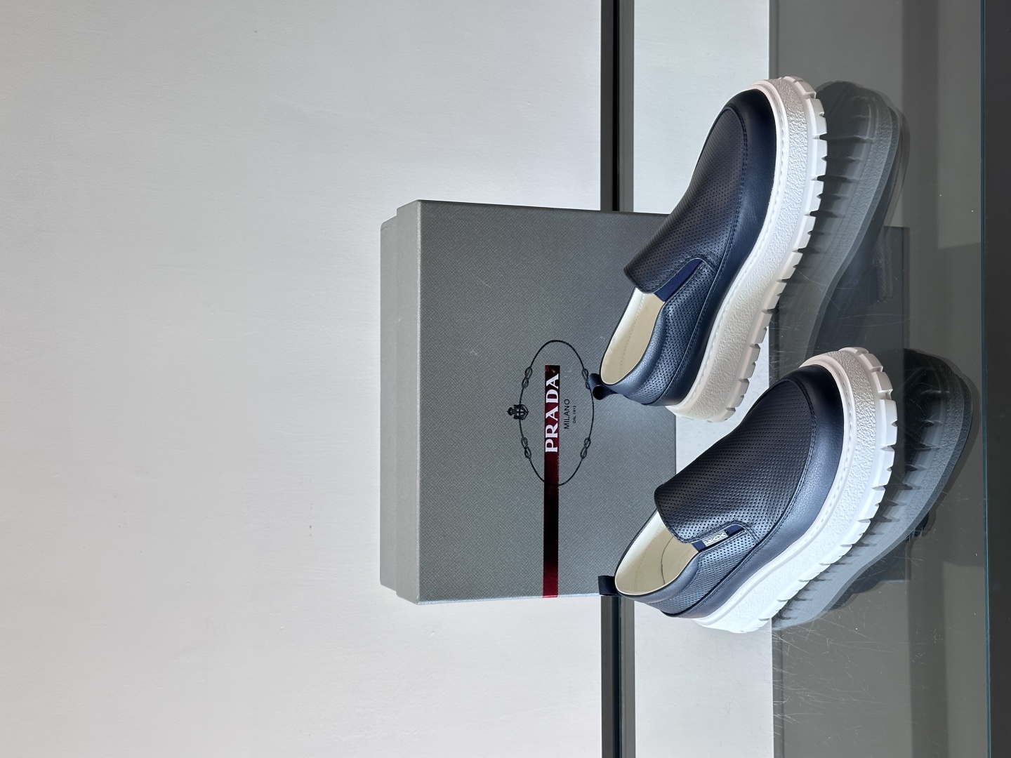 Prada/普拉达 男士新款一脚蹬懒人休闲鞋👟这款运动鞋采用光滑小牛皮革和摔纹牛皮拼接鞋面，一脚蹬乐福鞋