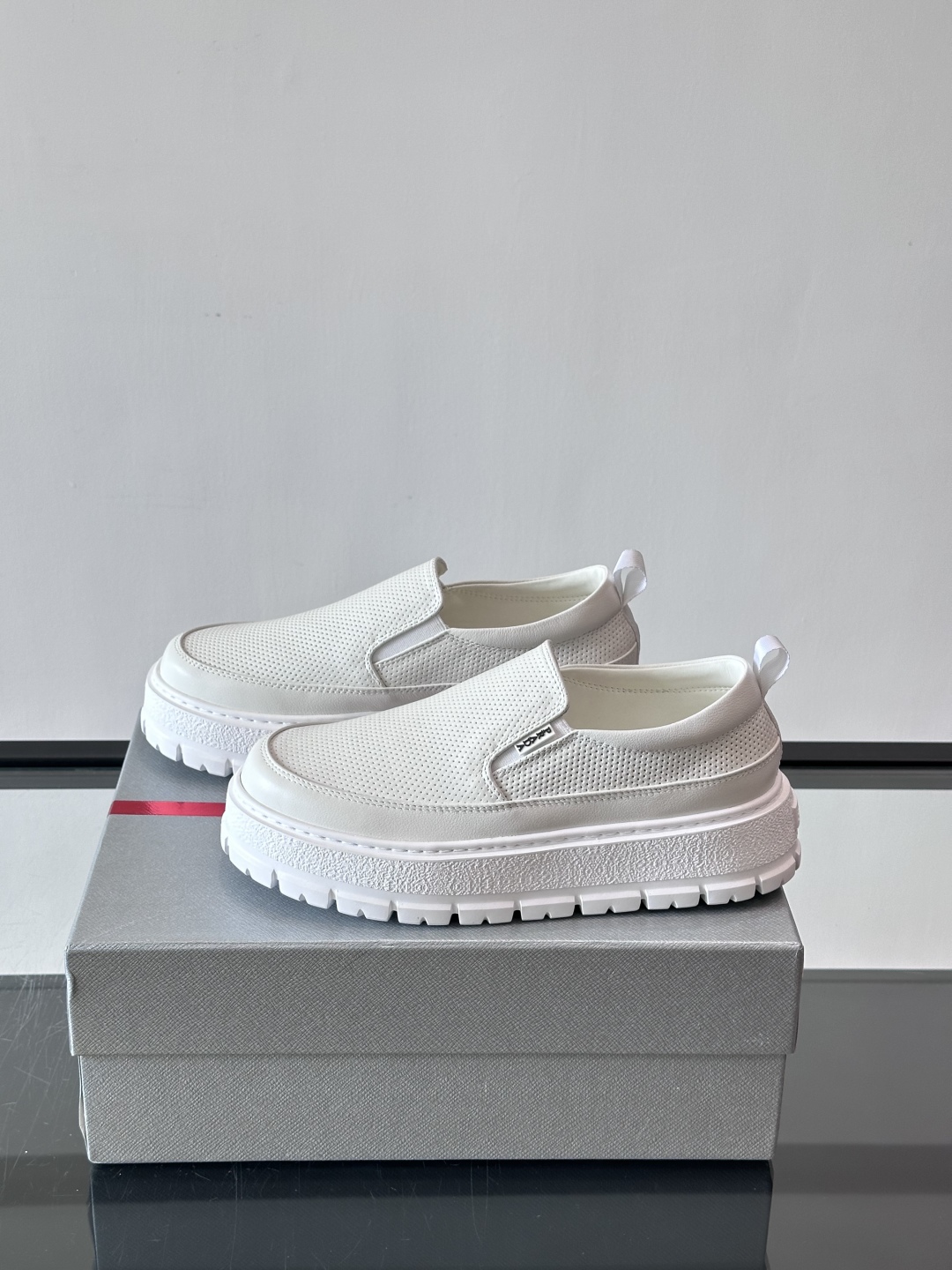 Prada/普拉达 男士新款一脚蹬懒人休闲鞋👟这款运动鞋采用光滑小牛皮革和摔纹牛皮拼接鞋面，一脚蹬乐福鞋