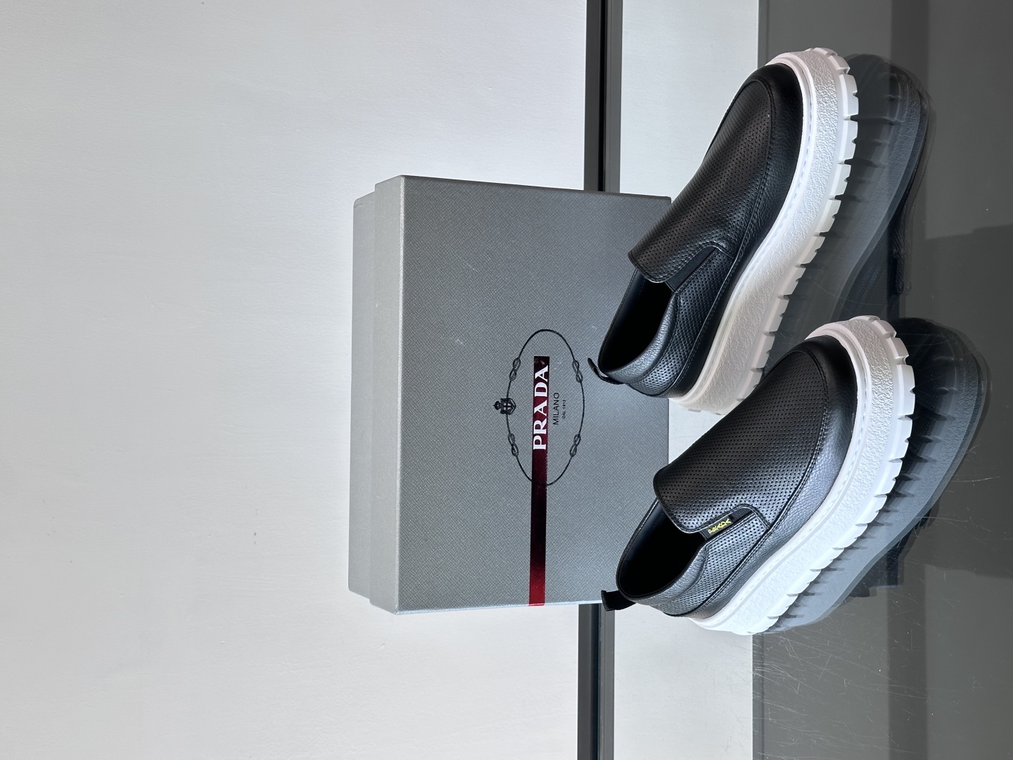 Prada/普拉达 男士新款一脚蹬懒人休闲鞋👟这款运动鞋采用光滑小牛皮革和摔纹牛皮拼接鞋面，一脚蹬乐福鞋