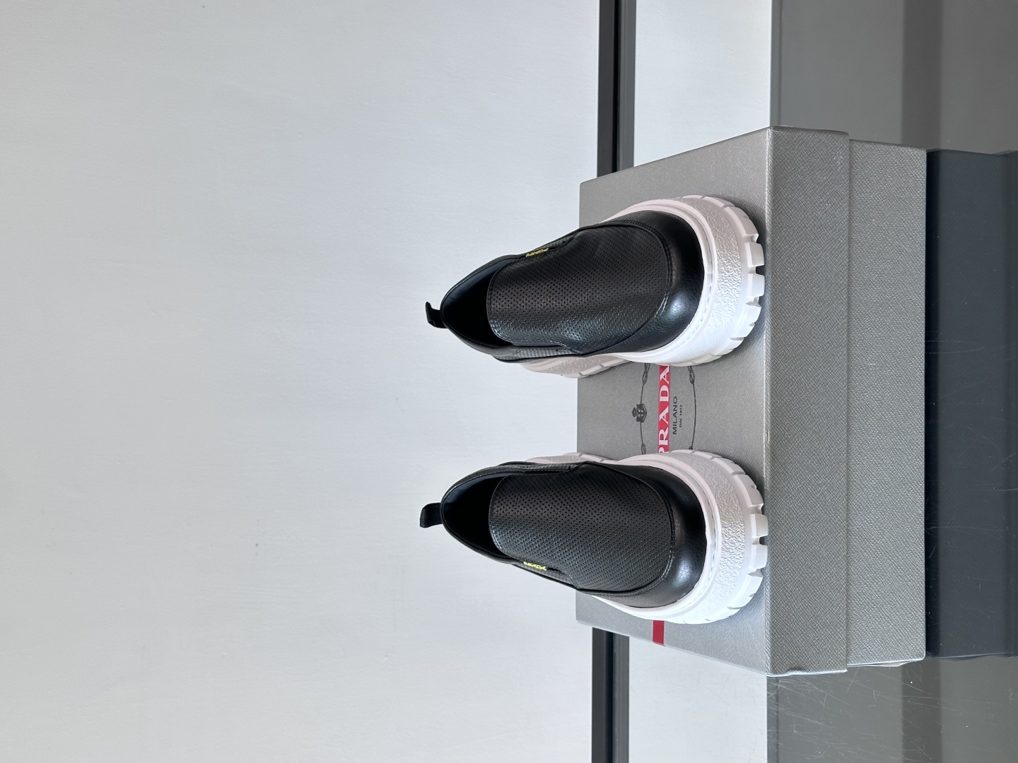 Prada/普拉达 男士新款一脚蹬懒人休闲鞋👟这款运动鞋采用光滑小牛皮革和摔纹牛皮拼接鞋面，一脚蹬乐福鞋