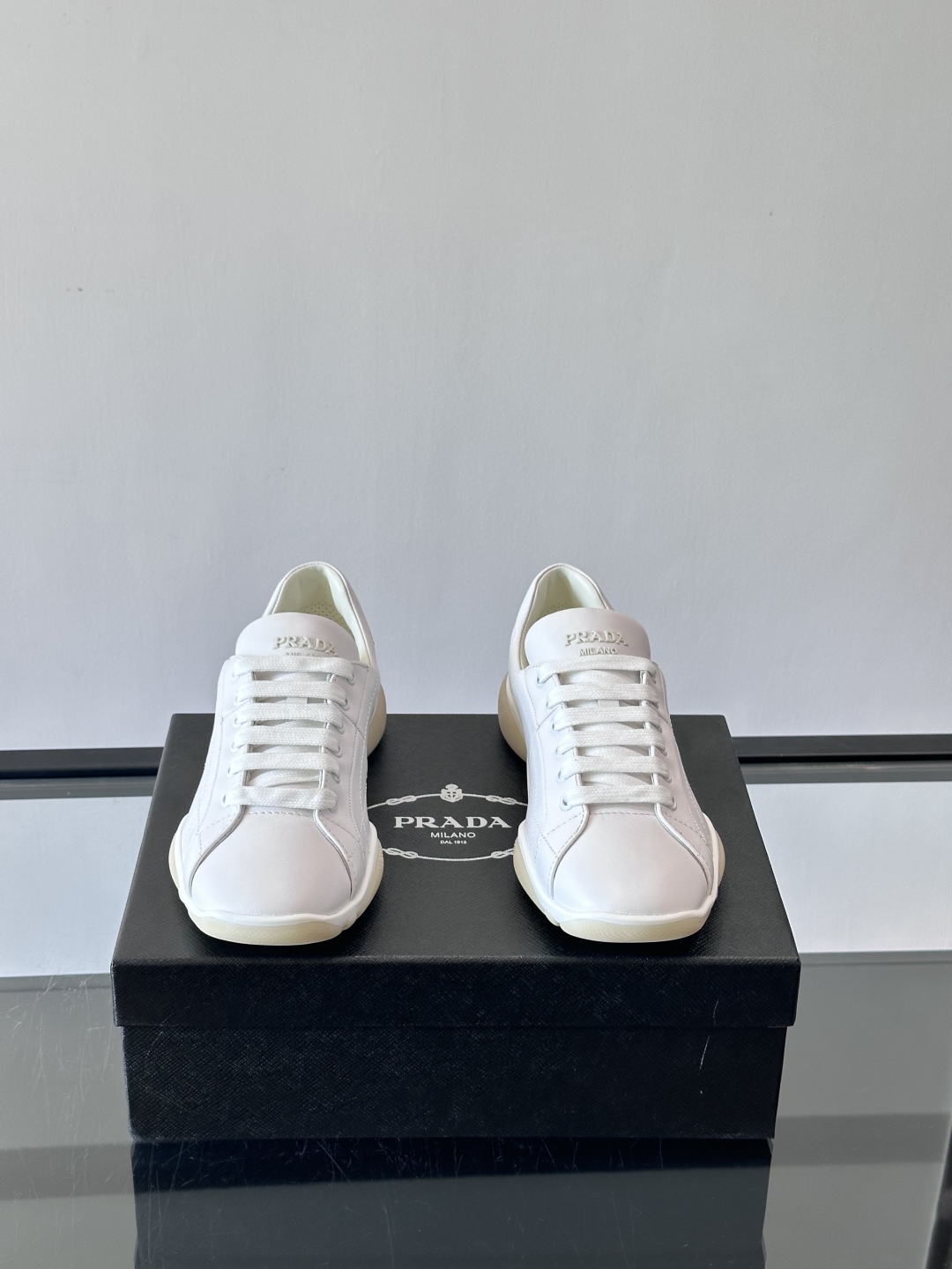 Prada NaPPa皮革运动鞋以精湛的缝线工艺勾勒出别具一格的几何纹理，搭配轻盈橡胶鞋底，彰显匠心工艺