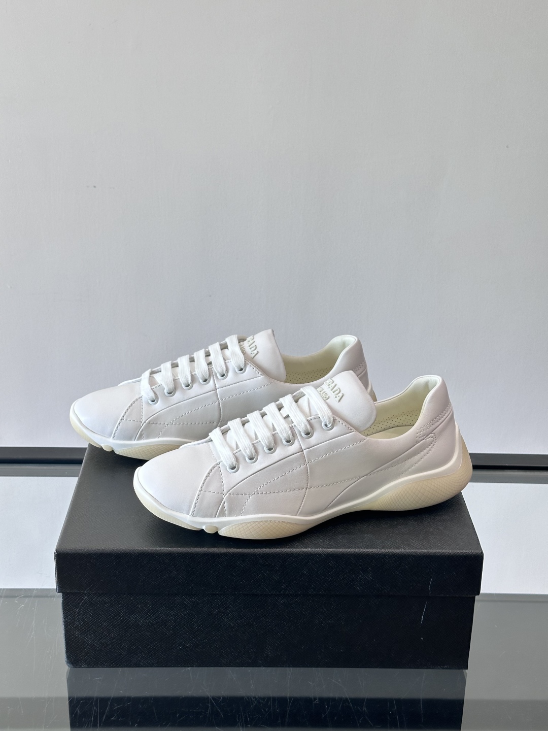 Prada NaPPa皮革运动鞋以精湛的缝线工艺勾勒出别具一格的几何纹理，搭配轻盈橡胶鞋底，彰显匠心工艺