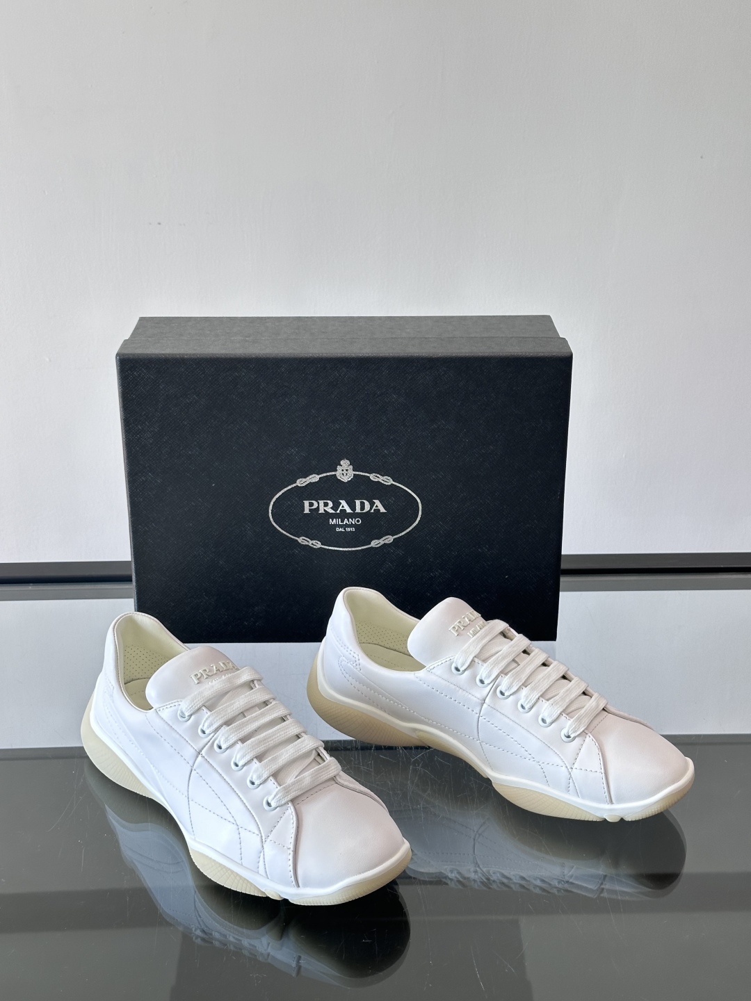 Prada NaPPa皮革运动鞋以精湛的缝线工艺勾勒出别具一格的几何纹理，搭配轻盈橡胶鞋底，彰显匠心工艺