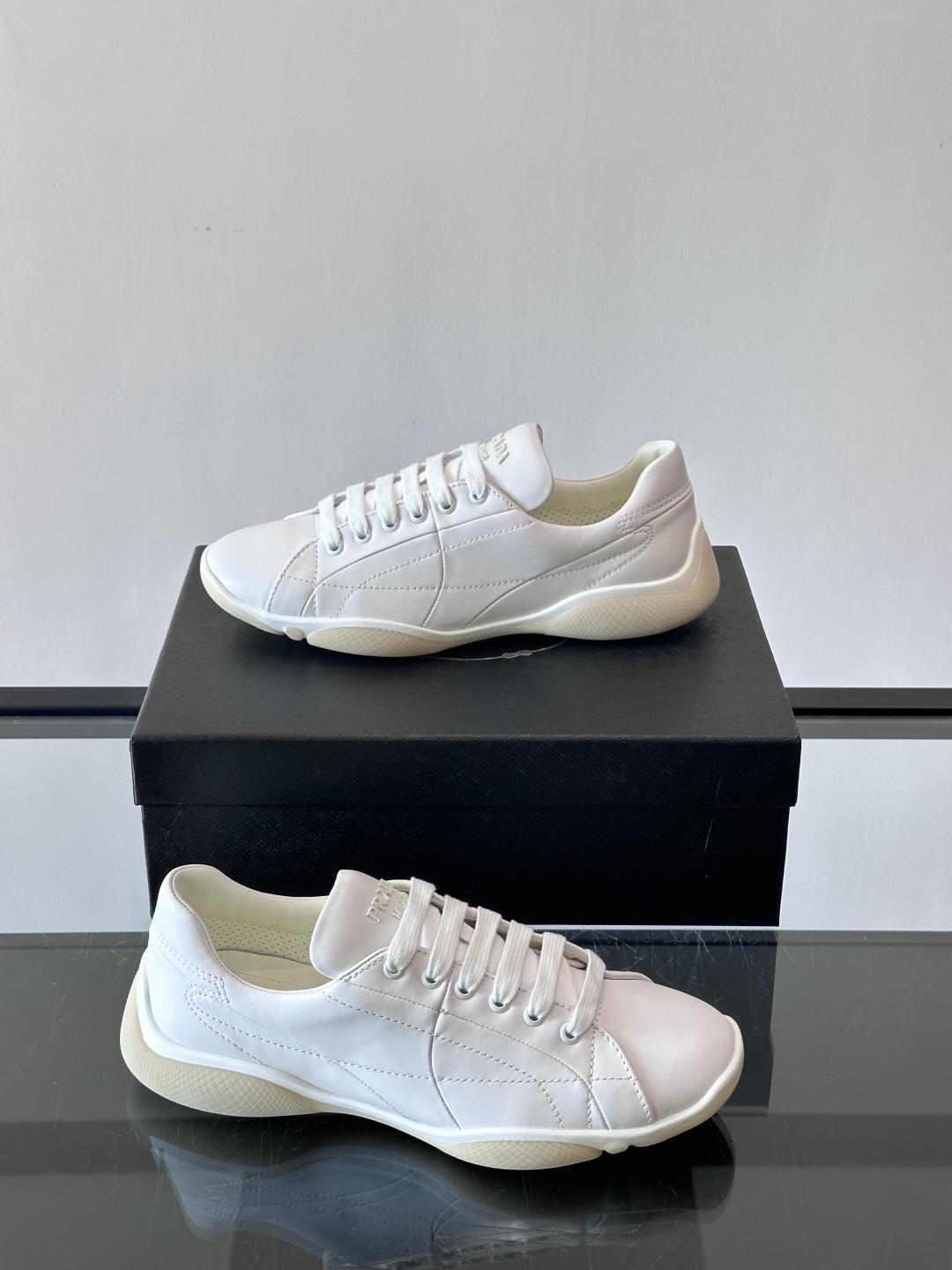 Prada NaPPa皮革运动鞋以精湛的缝线工艺勾勒出别具一格的几何纹理，搭配轻盈橡胶鞋底，彰显匠心工艺