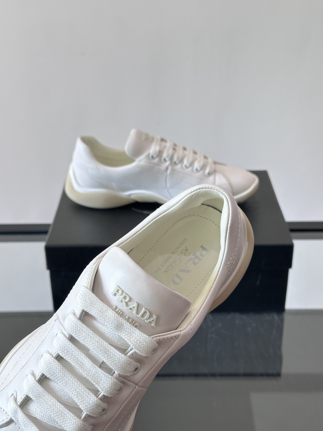Prada NaPPa皮革运动鞋以精湛的缝线工艺勾勒出别具一格的几何纹理，搭配轻盈橡胶鞋底，彰显匠心工艺