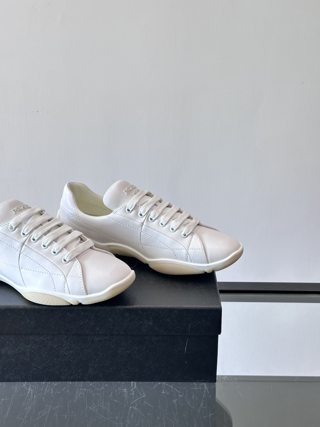 Prada NaPPa皮革运动鞋以精湛的缝线工艺勾勒出别具一格的几何纹理，搭配轻盈橡胶鞋底，彰显匠心工艺