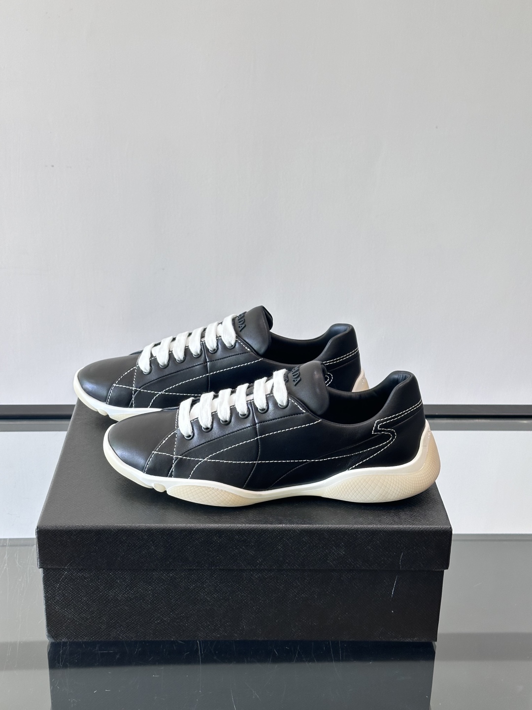 Prada NaPPa皮革运动鞋以精湛的缝线工艺勾勒出别具一格的几何纹理，搭配轻盈橡胶鞋底，彰显匠心工艺