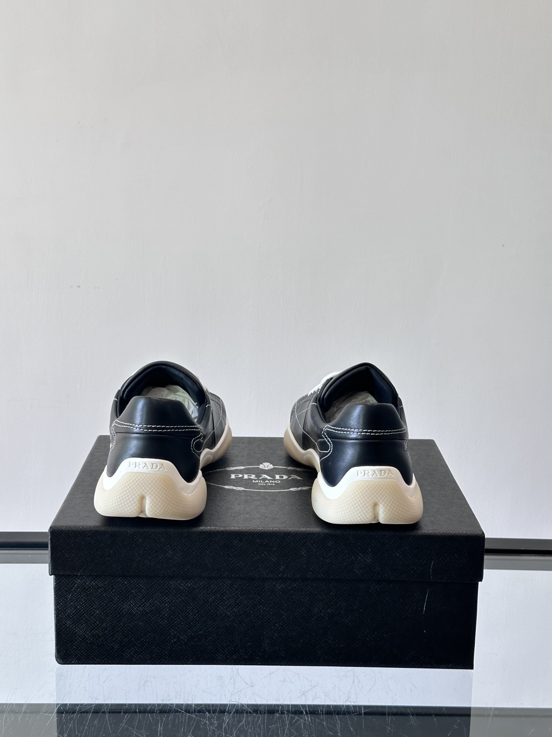 Prada NaPPa皮革运动鞋以精湛的缝线工艺勾勒出别具一格的几何纹理，搭配轻盈橡胶鞋底，彰显匠心工艺