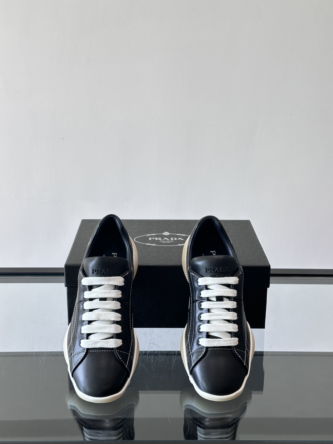 Prada NaPPa皮革运动鞋以精湛的缝线工艺勾勒出别具一格的几何纹理，搭配轻盈橡胶鞋底，彰显匠心工艺