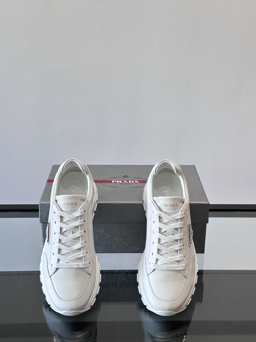 Prada/普拉达 男士新款运动休闲鞋，这款运动鞋鞋面采用进口小牛皮。外侧饰以P家经典金属三角珐琅徽标，