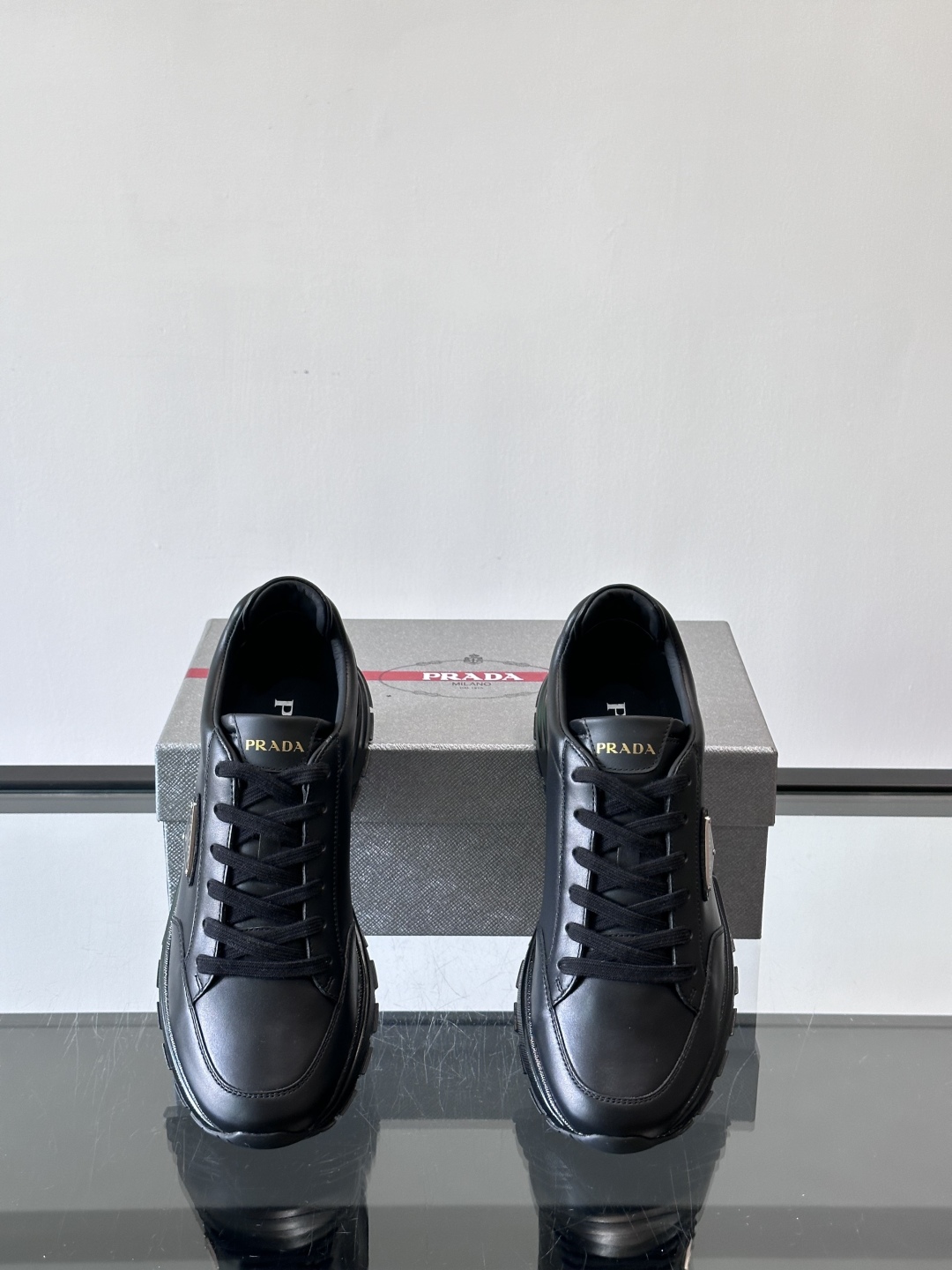 Prada/普拉达 男士新款运动休闲鞋，这款运动鞋鞋面采用进口小牛皮。外侧饰以P家经典金属三角珐琅徽标，