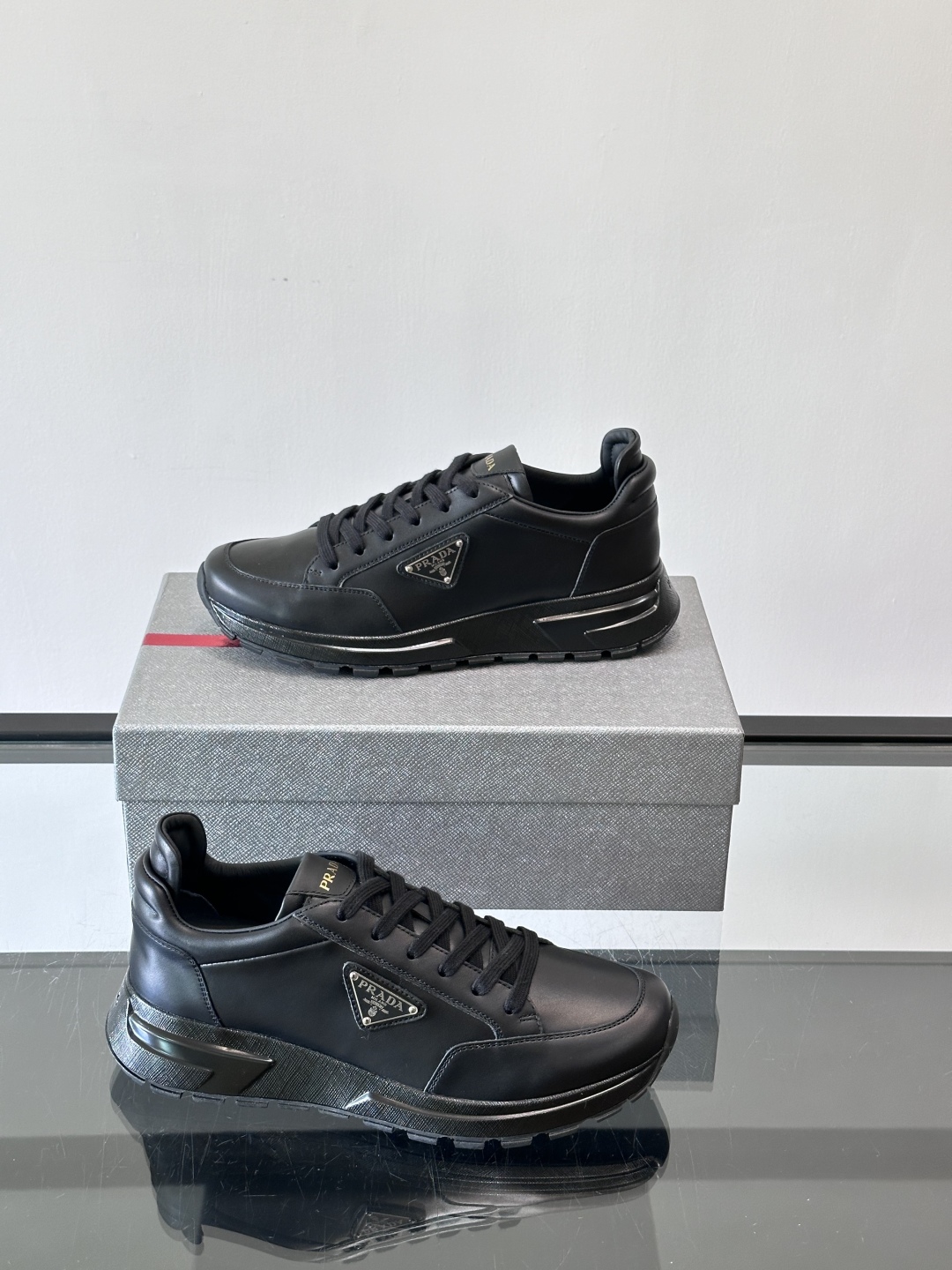 Prada/普拉达 男士新款运动休闲鞋，这款运动鞋鞋面采用进口小牛皮。外侧饰以P家经典金属三角珐琅徽标，