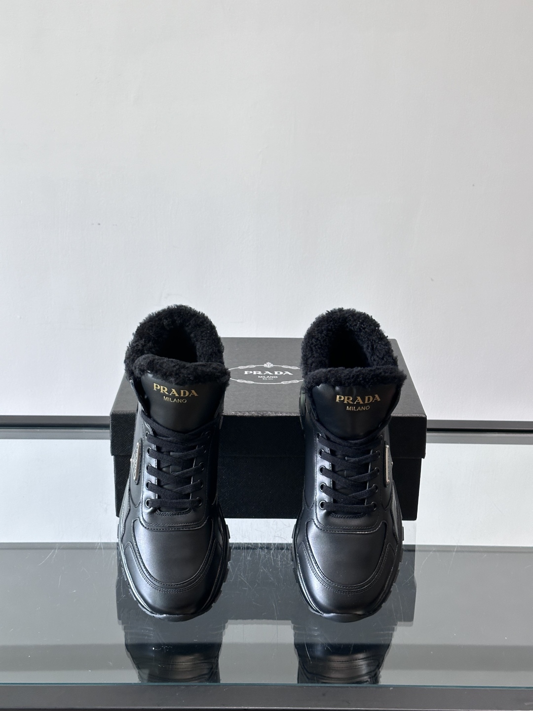 PRADA/普拉达 男士新款高帮运动鞋，这款厚底运动鞋采用牛皮鞋面制成，搭配加厚橡胶发泡中底拼接前后包裹