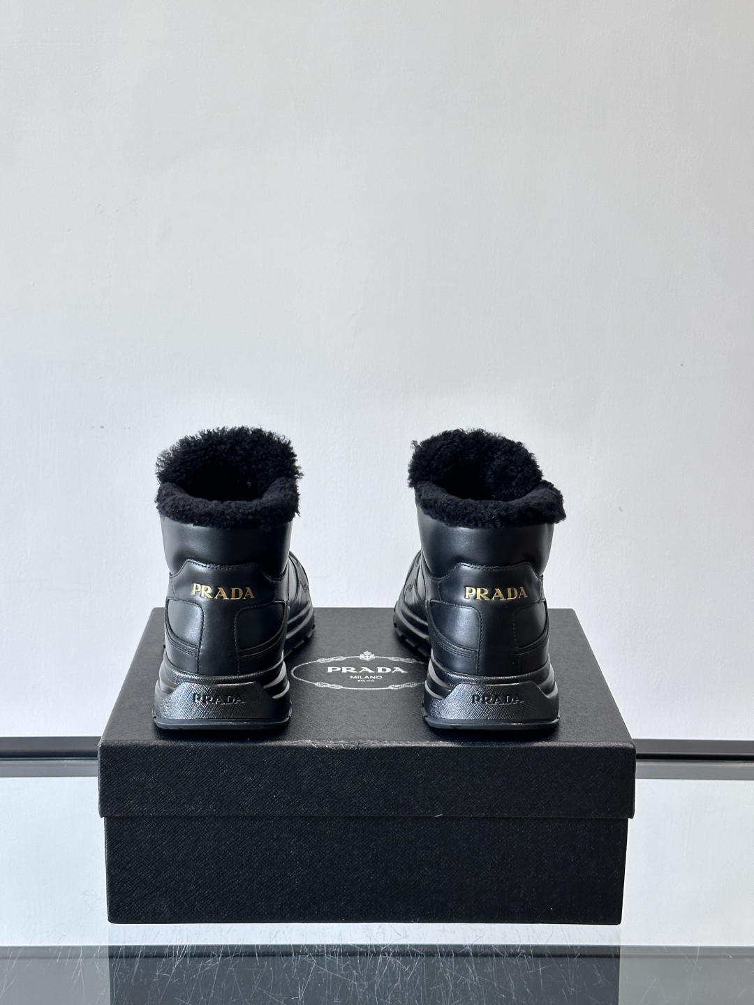 PRADA/普拉达 男士新款高帮运动鞋，这款厚底运动鞋采用牛皮鞋面制成，搭配加厚橡胶发泡中底拼接前后包裹