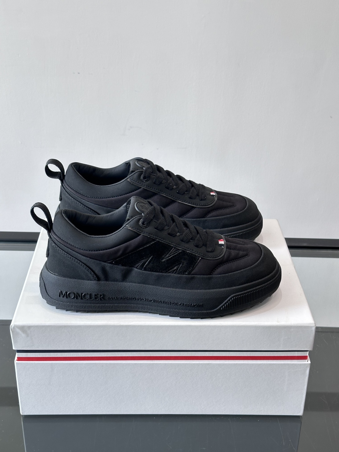 Moncler这款休闲运动鞋，主打简约百搭风，鞋面拼接米白+浅灰，蓝色橡胶鞋底和侧边点缀超有活力。鞋舌和