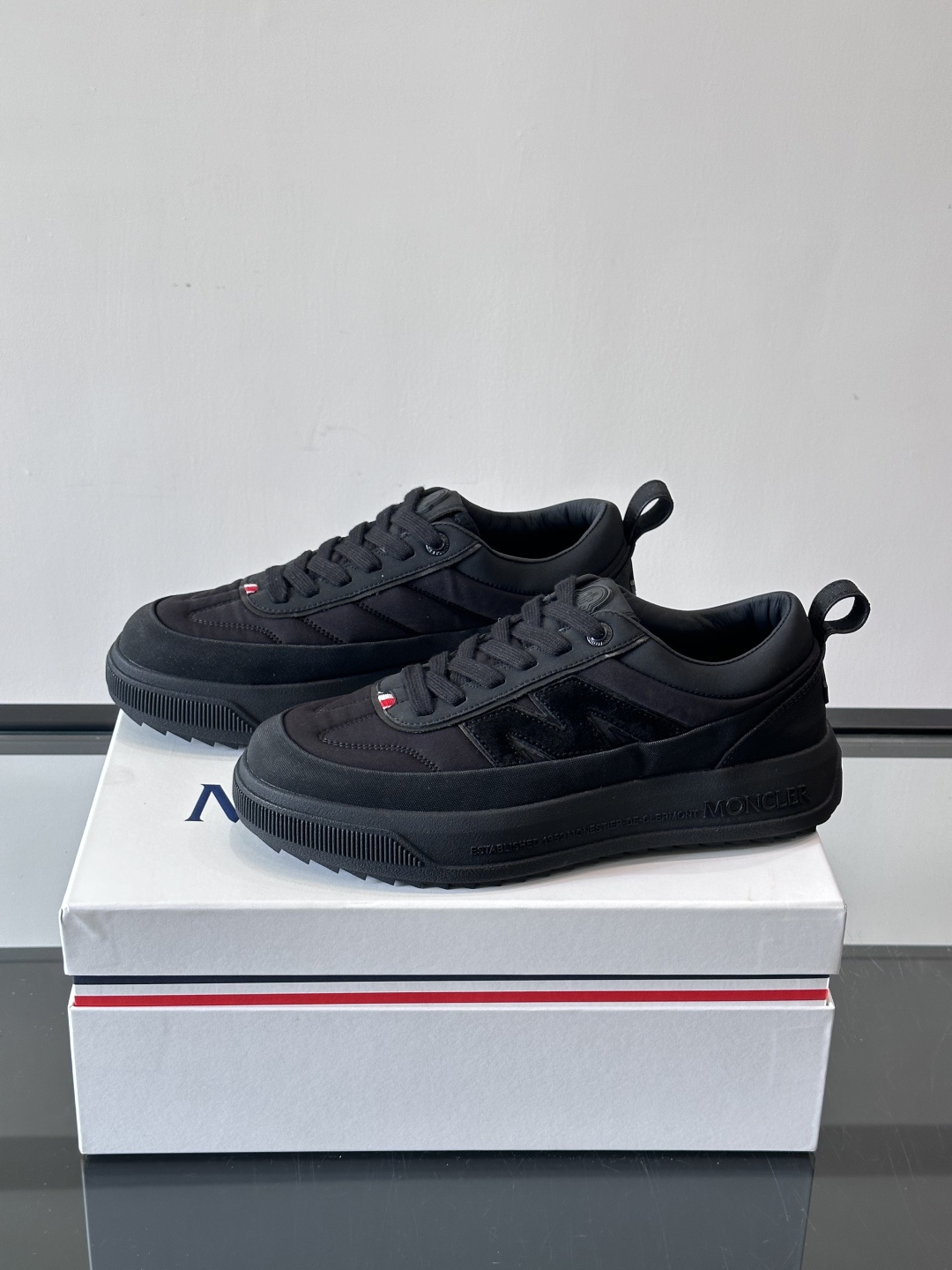 Moncler这款休闲运动鞋，主打简约百搭风，鞋面拼接米白+浅灰，蓝色橡胶鞋底和侧边点缀超有活力。鞋舌和