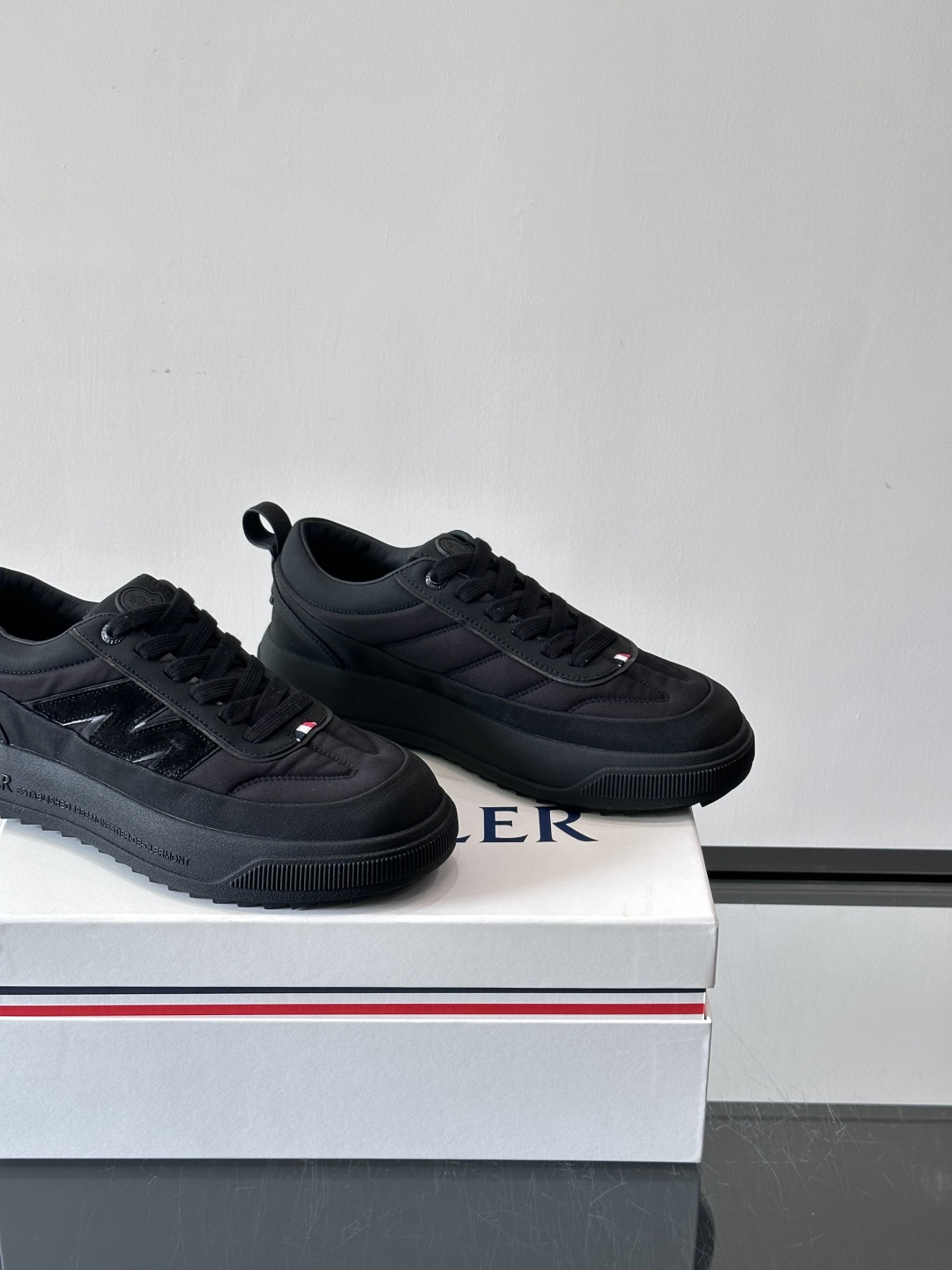 Moncler这款休闲运动鞋，主打简约百搭风，鞋面拼接米白+浅灰，蓝色橡胶鞋底和侧边点缀超有活力。鞋舌和