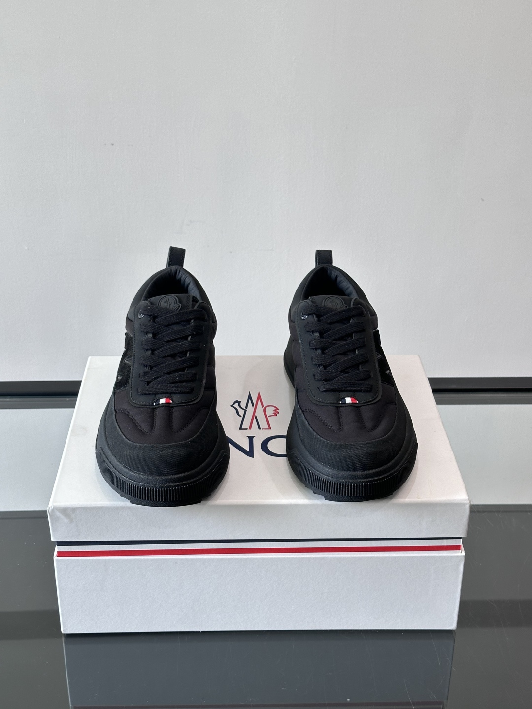 Moncler这款休闲运动鞋，主打简约百搭风，鞋面拼接米白+浅灰，蓝色橡胶鞋底和侧边点缀超有活力。鞋舌和