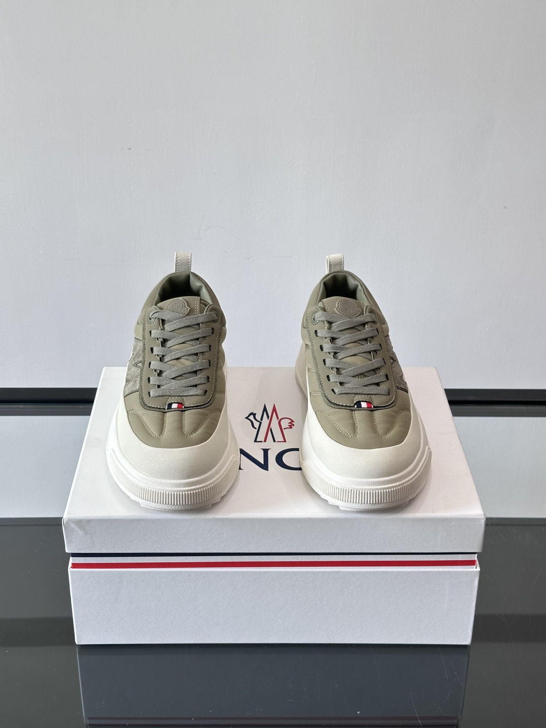 Moncler这款休闲运动鞋，主打简约百搭风，鞋面拼接米白+浅灰，蓝色橡胶鞋底和侧边点缀超有活力。鞋舌和