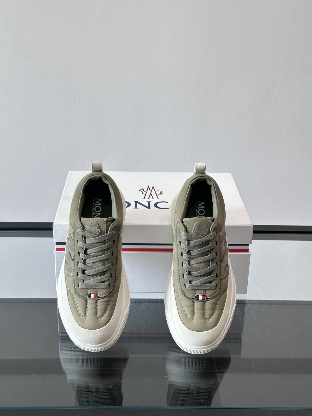 Moncler这款休闲运动鞋，主打简约百搭风，鞋面拼接米白+浅灰，蓝色橡胶鞋底和侧边点缀超有活力。鞋舌和