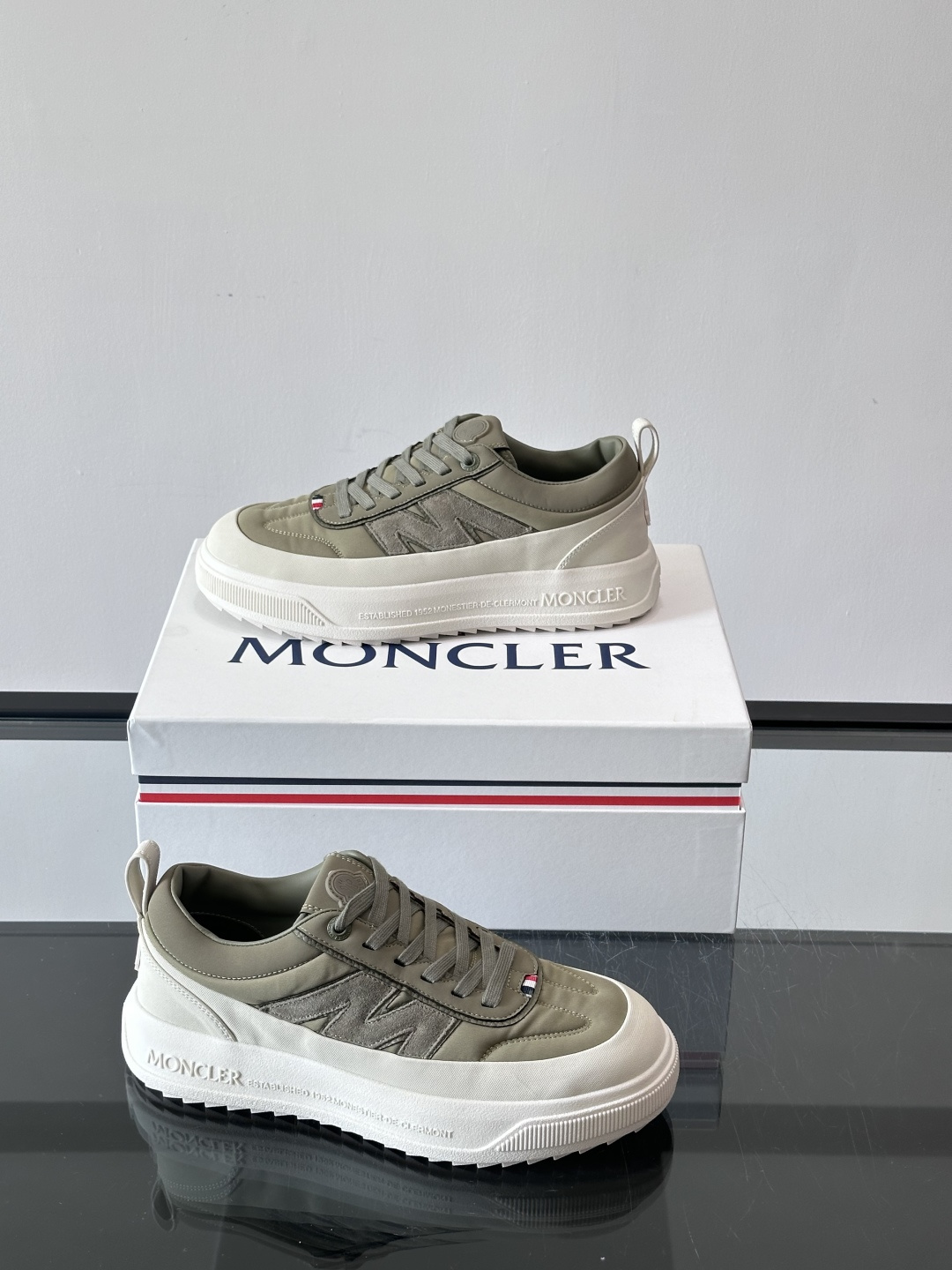 Moncler这款休闲运动鞋，主打简约百搭风，鞋面拼接米白+浅灰，蓝色橡胶鞋底和侧边点缀超有活力。鞋舌和