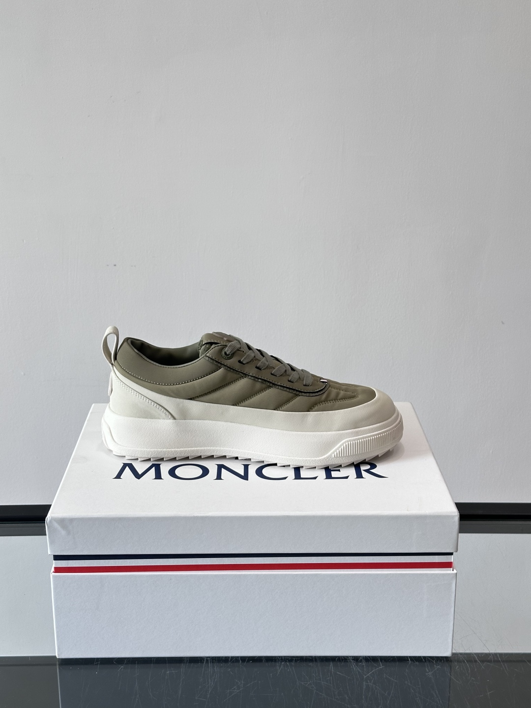 Moncler这款休闲运动鞋，主打简约百搭风，鞋面拼接米白+浅灰，蓝色橡胶鞋底和侧边点缀超有活力。鞋舌和