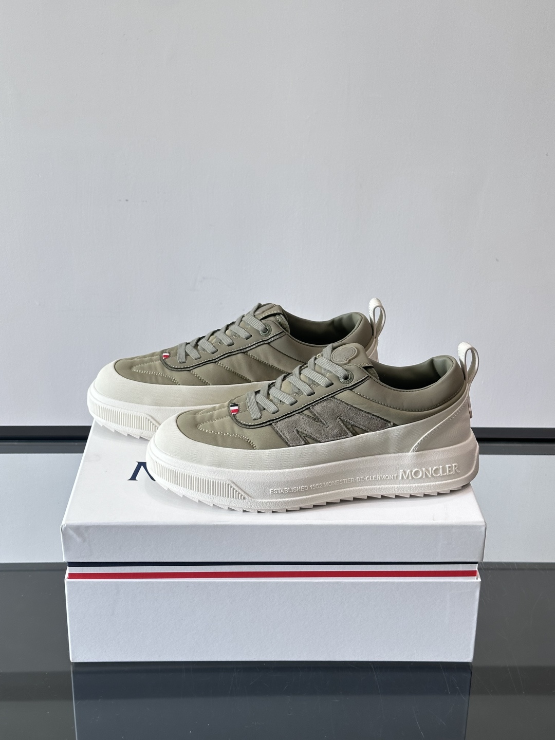 Moncler这款休闲运动鞋，主打简约百搭风，鞋面拼接米白+浅灰，蓝色橡胶鞋底和侧边点缀超有活力。鞋舌和